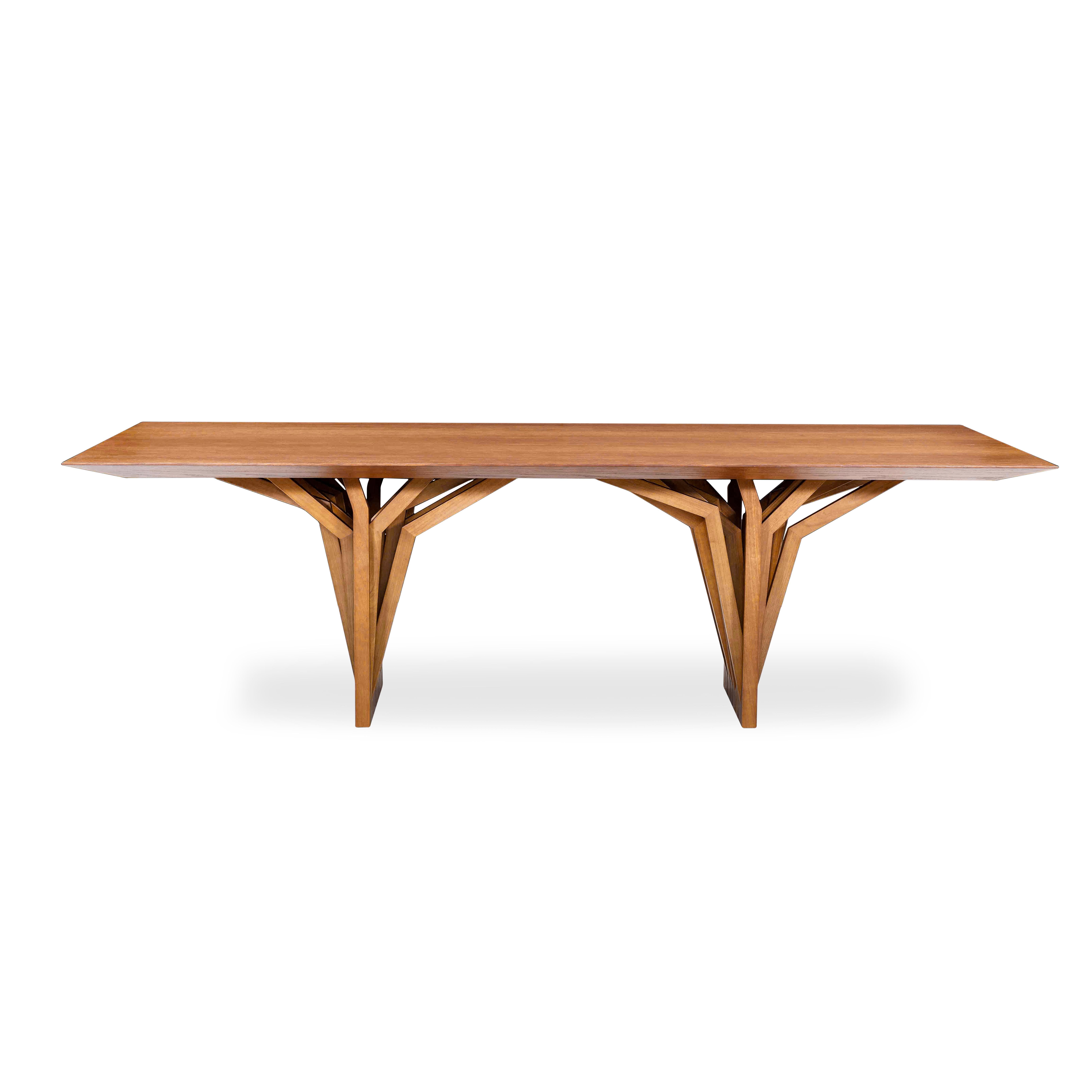 La table de salle à manger Radi est un chef-d'œuvre avec un plateau en placage de bois finition chêne et une base de table originale en forme d'ancre de toit, inspirée par les racines aériennes des arbres. Cette table de salle à manger est une pièce
