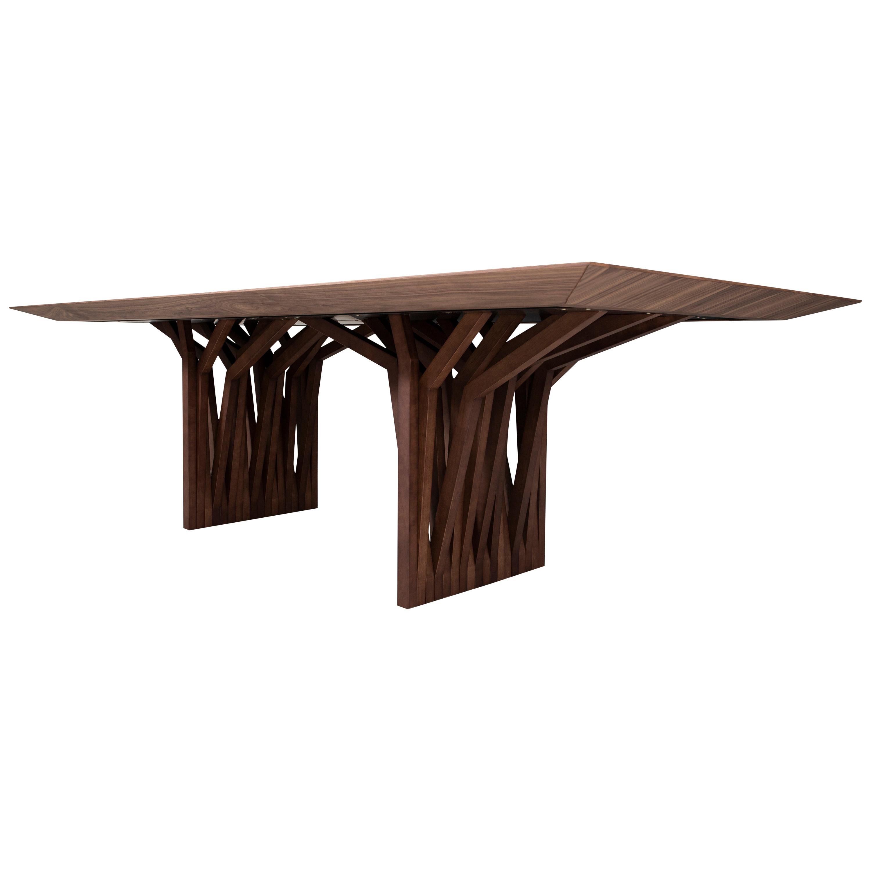 Der Radi Esstisch ist ein Meisterwerk mit einer Platte aus nussbaumfarbenem Furnier und einem originellen Tischfuß mit Dachanker, der von den Luftwurzeln der Bäume inspiriert ist. Dieser Esstisch ist ein sehr einfaches Stück, das das Uultis-Team mit