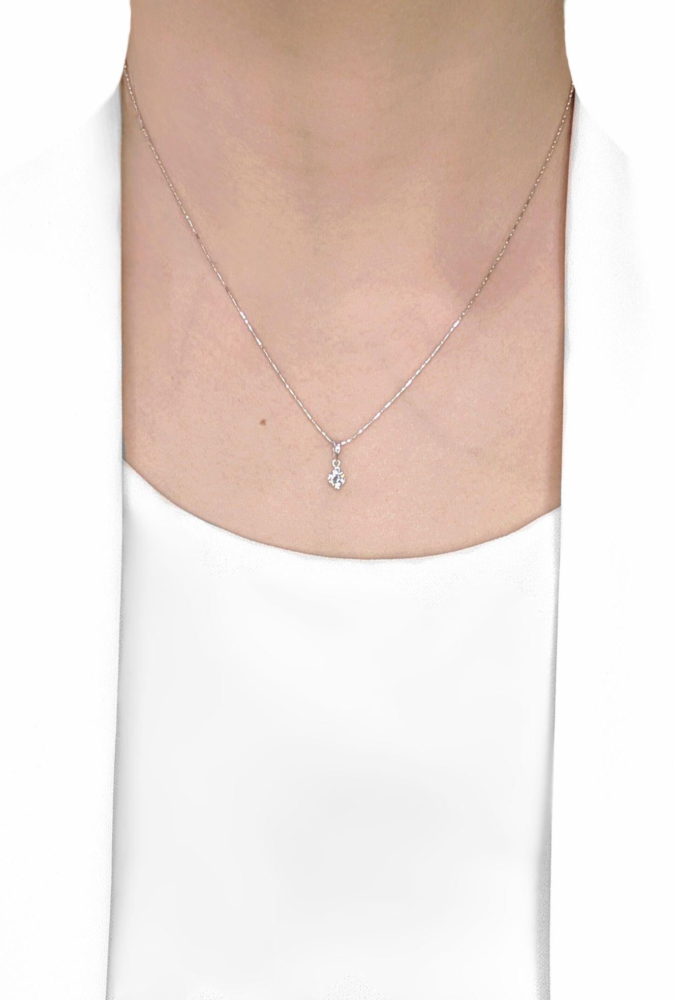Ornez votre décolleté de l'éclat intemporel de ce pendentif solitaire classique, méticuleusement réalisé en or blanc 18 carats rayonnant. En son cœur, un diamant rond naturel de 0,20ct brille d'un feu exceptionnel. Ce diamant exquis présente un