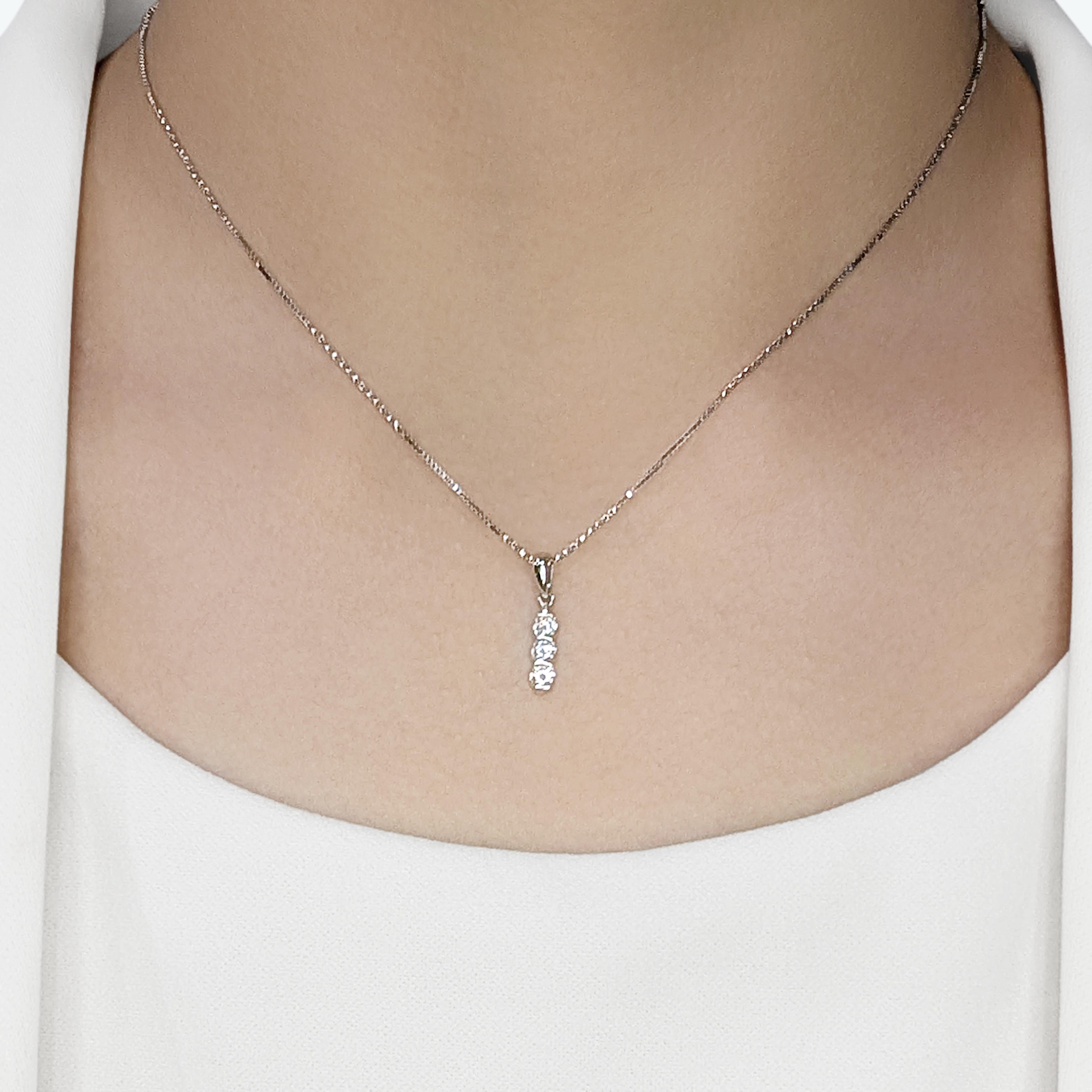 Eleganza con questa splendida collana in oro bianco 18 carati, impreziosita da tre squisiti diamanti naturali per un peso totale di 0,2 carati. Ogni diamante vanta un eccezionale taglio brillante rotondo, classificato F per il suo colore radioso e