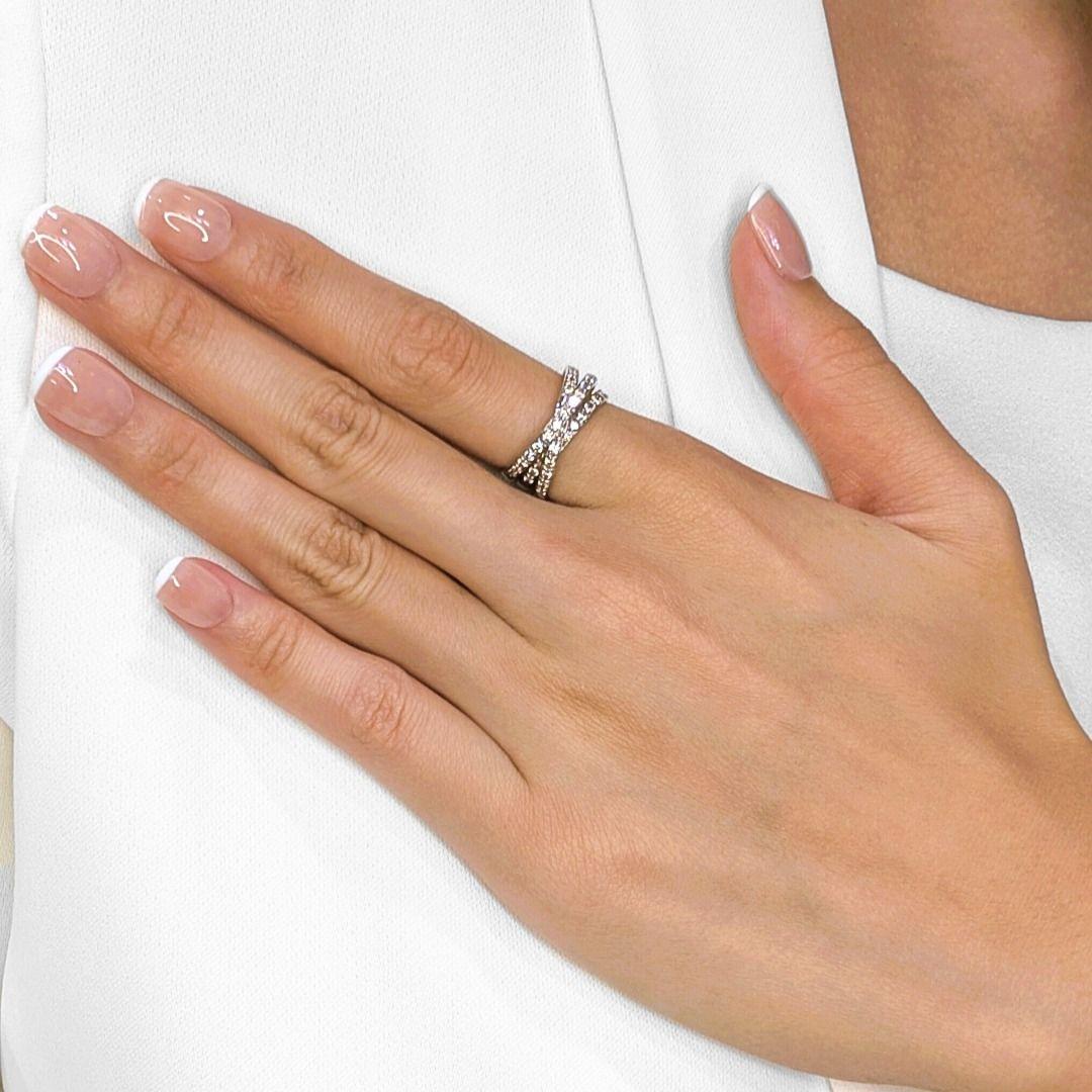 Crafted in luminous 18K white gold, this exquisite crossover ring features 32 natural round brilliant diamonds totaling 0.64 carats. The elegant crisscross design creates a fluid, modern silhouette that sparkles from every angle. With diamonds of G
