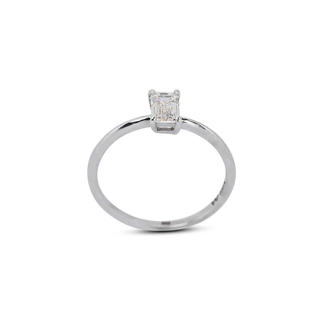 Radiant 0.70ct Emerald-Cut Solitaire Diamond Ring in 18k White Gold - Certifié GIA

Dévoilez l'essence de la sophistication pure avec cette exquise bague solitaire en diamant, façonnée en or blanc 18 carats. Un diamant taille émeraude de 0,70 carat