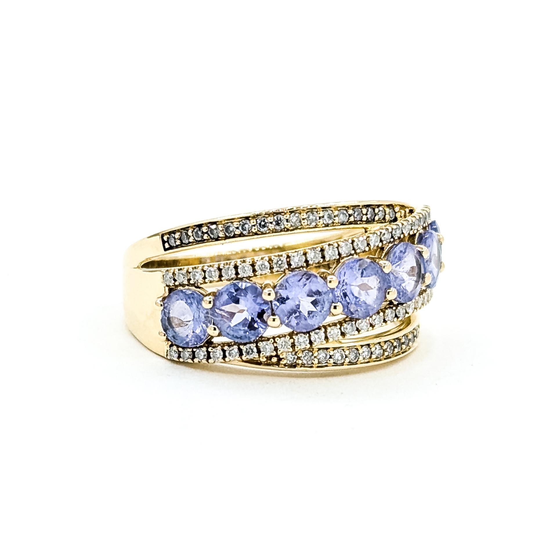 Dieser strahlende Ring ist aus 14 Karat Gelbgold gefertigt und zeigt ein auffälliges Crossover-Design, das mit leuchtenden Tansaniten und funkelnden Diamanten besetzt ist. Die Tansanite von insgesamt 1,75 Karat haben einen faszinierenden