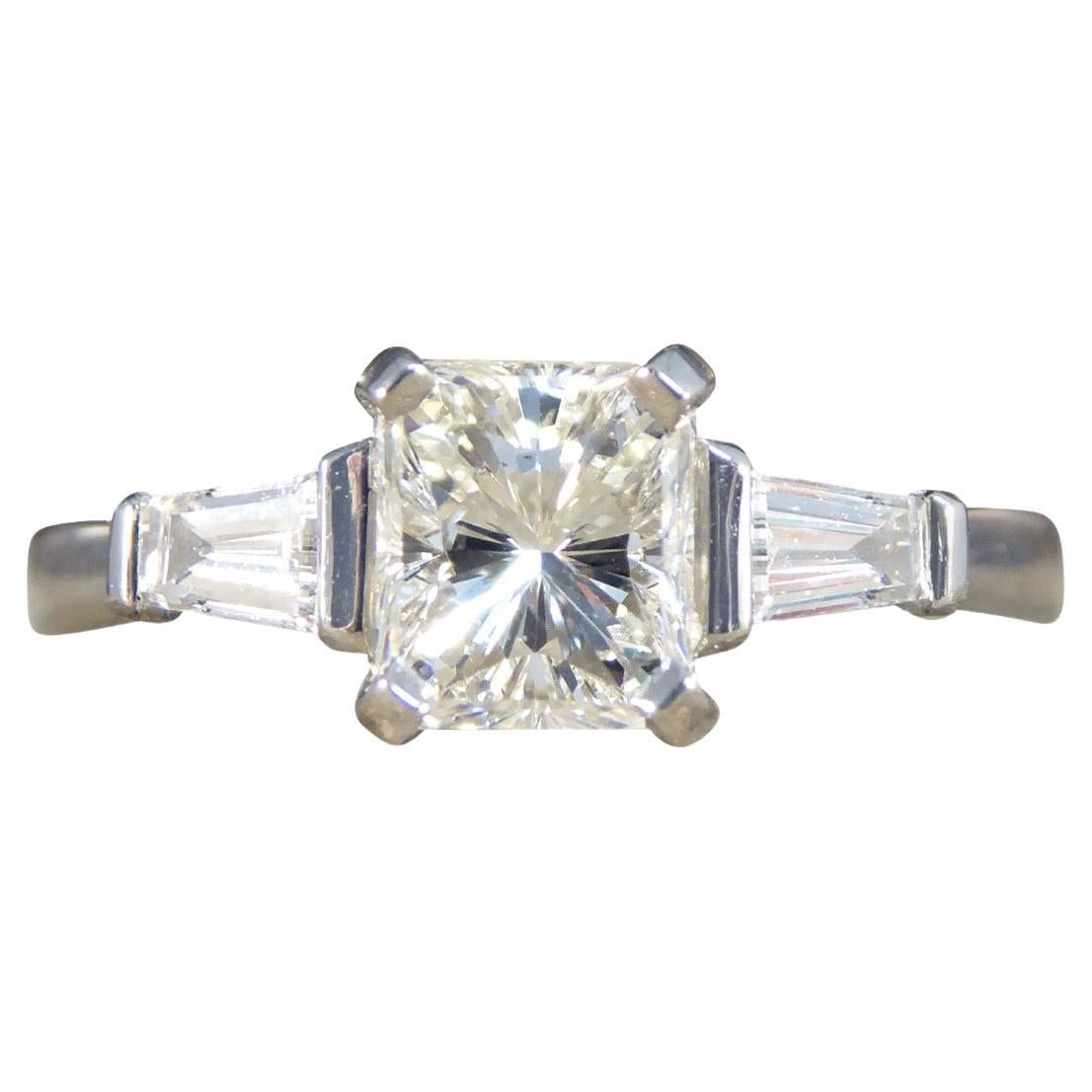 Ring mit Diamant im Strahlenschliff und konisch zulaufenden Baguette-Schulter aus Platin