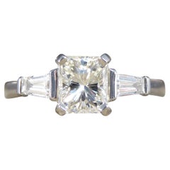 Ring mit Diamant im Strahlenschliff und konisch zulaufenden Baguette-Schulter aus Platin