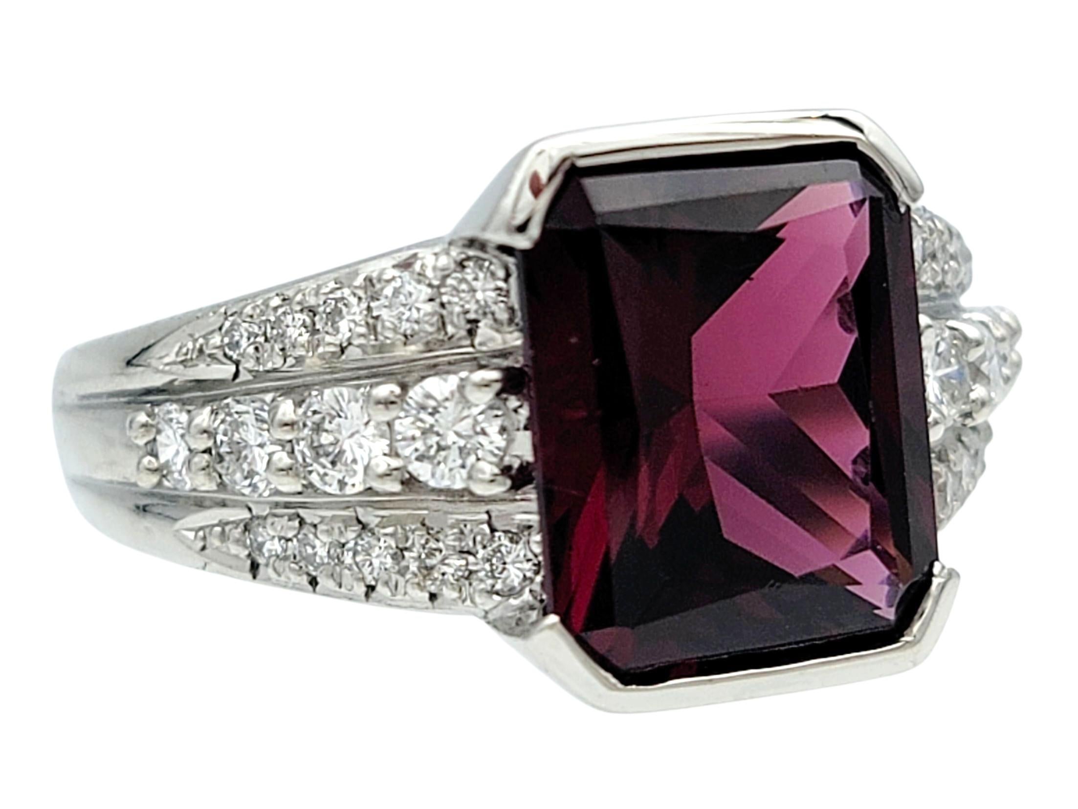 Taille de l'anneau : 7

Cette étonnante bague en platine présente en son centre un grenat rouge foncé radiant taillé en escalier, encadré dans un élégant demi-biseau qui met en valeur sa riche saturation et sa géométrie nette. La large bande est
