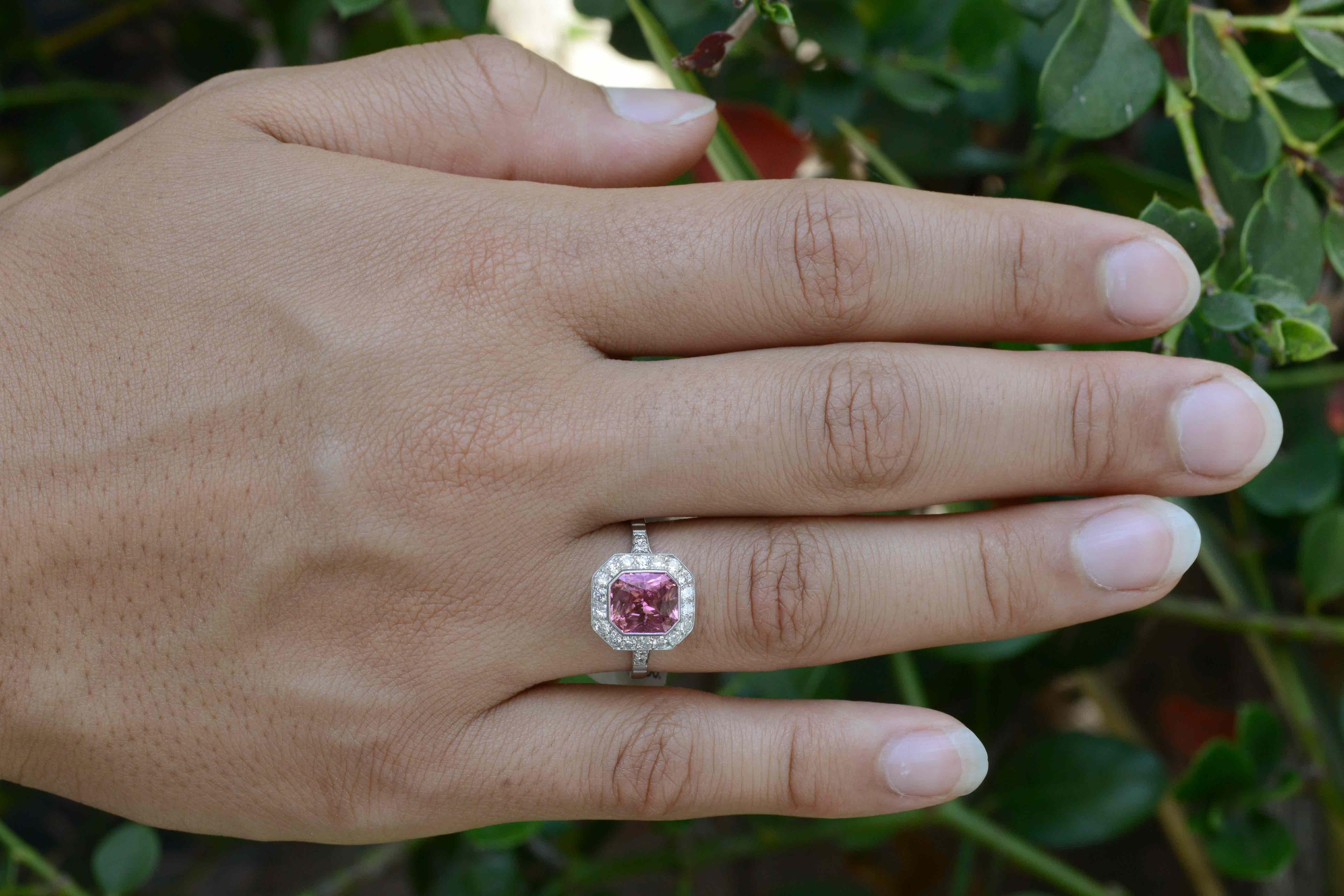 The incredible hot pink of this natural sapphire is almost overwhelming....almost. The Art Deco inspired platinum halo is lined with dazzling round diamonds and framed in feminine milgrain. The sleek, octagon silhouette features a low, bezel setting