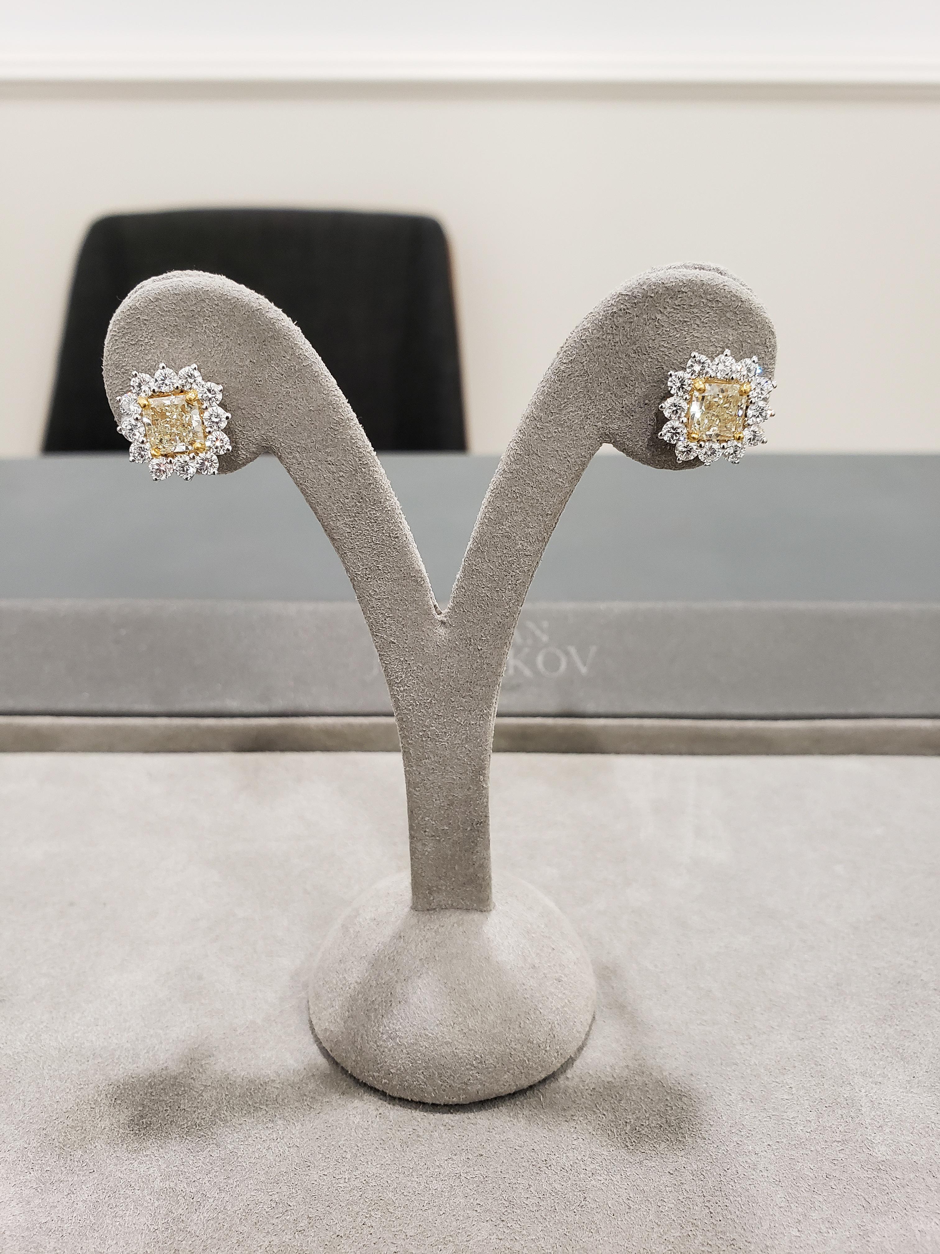 Showcases radiant cut yellow diamonds weighing 2.26 carats total, surrounded by a halo of round brilliant diamonds weighing 1.58 carats total. Set in a floral motif made in platinum.

