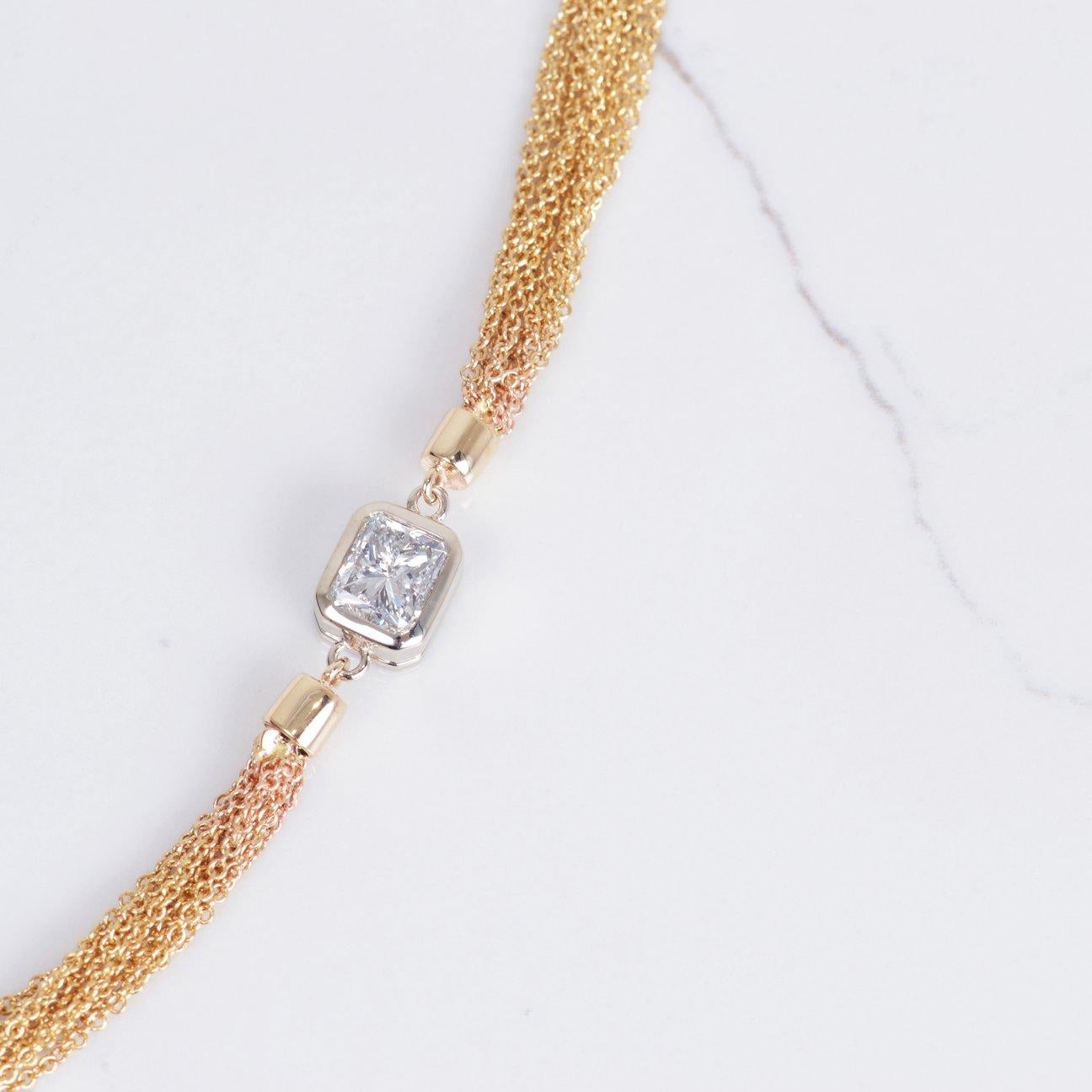 This necklace is a true statement piece! With a 1.07ct radiant cut diamond beautifully set off to the side in 14k white gold bezel and placed on a 14k yellow gold multiple chain necklace. Necklace weighs 14.2 grams and is 18in in length.