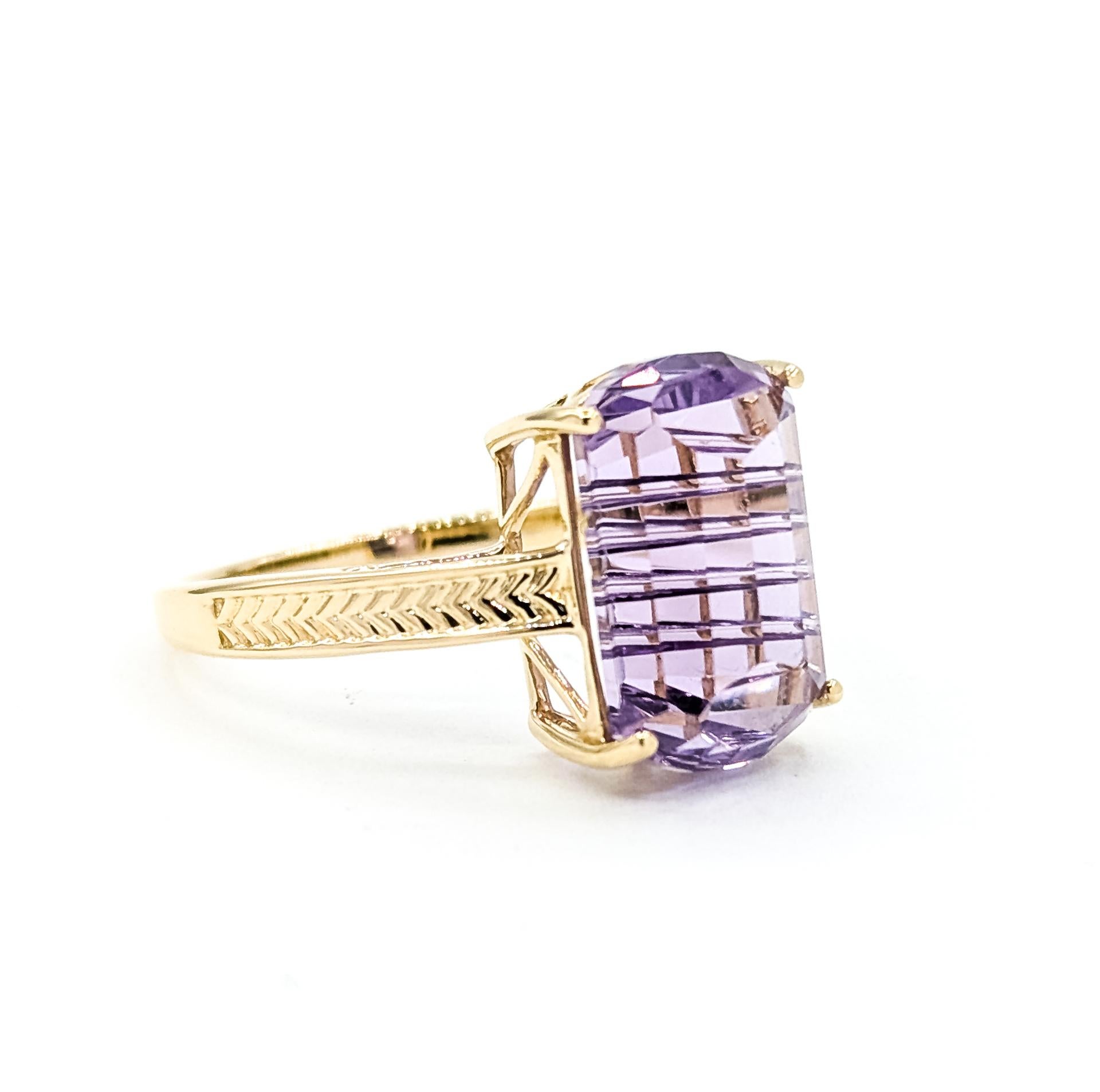 Questo anello radioso è realizzato in oro giallo 14k e mette in mostra un'incantevole ametista dal taglio fantasy del peso di 7,00 carati. La sfaccettatura unica della gemma mostra intricati riflessi geometrici, creando una profondità e una