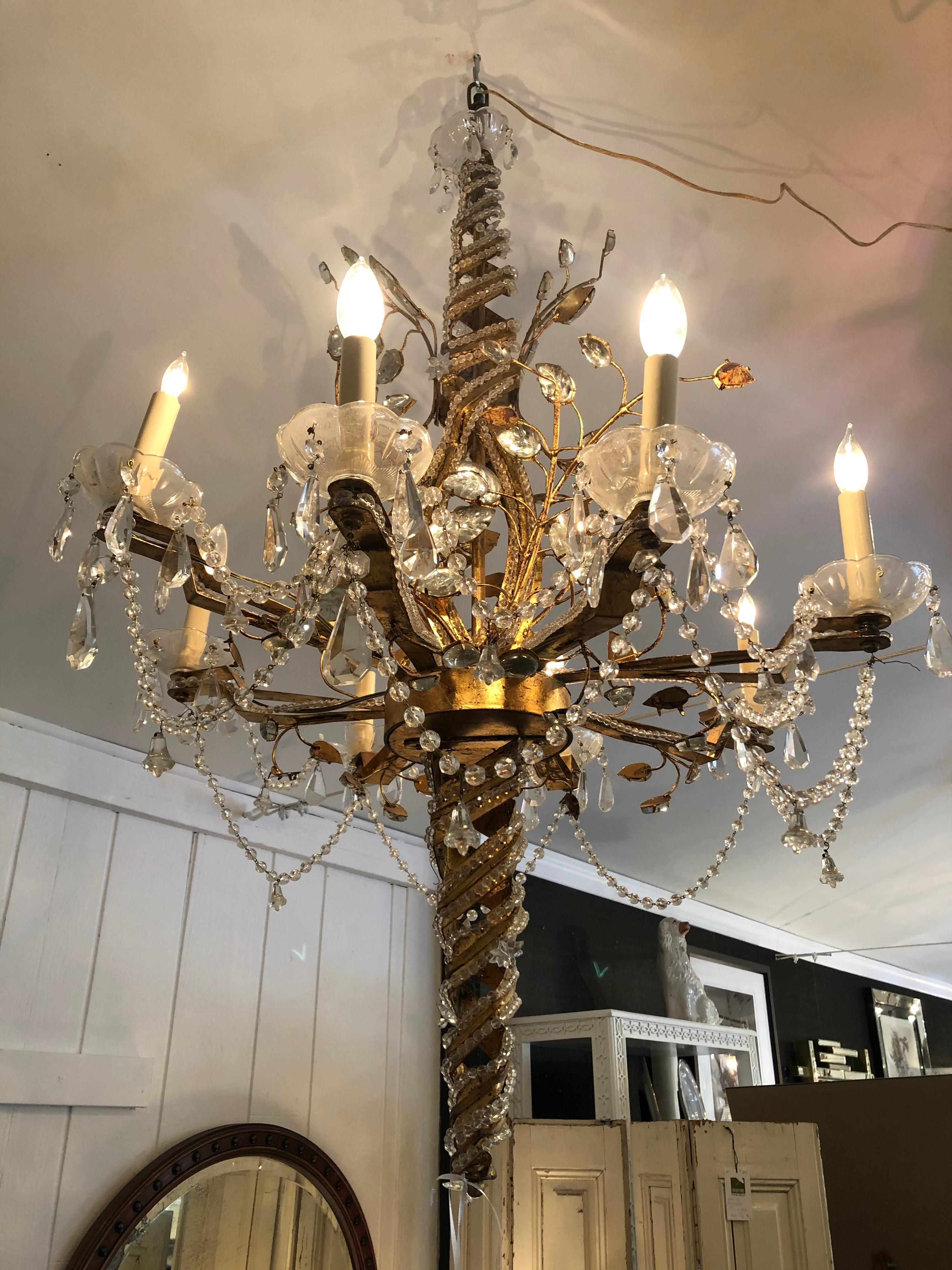 Maison Baguès remains the last word in classic French lighting, and this large ornate chandelier is emblematic of their craftsmanship and glamorous sophistication. A twisted braided cone of gilt and crystals creates the central shaft, having 8 arms,