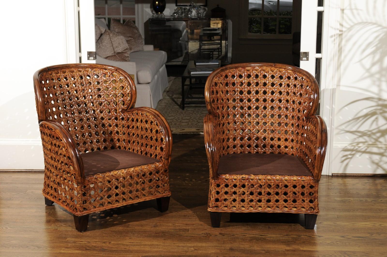 An exquisite restored pair of rattan Art Deco Revival club chairs, circa 1980. Fabulous rattan frame construction completely veneered in heavy French Cane. Design, quality and craftsmanship that is beyond incredible. The pieces have aged to absolute