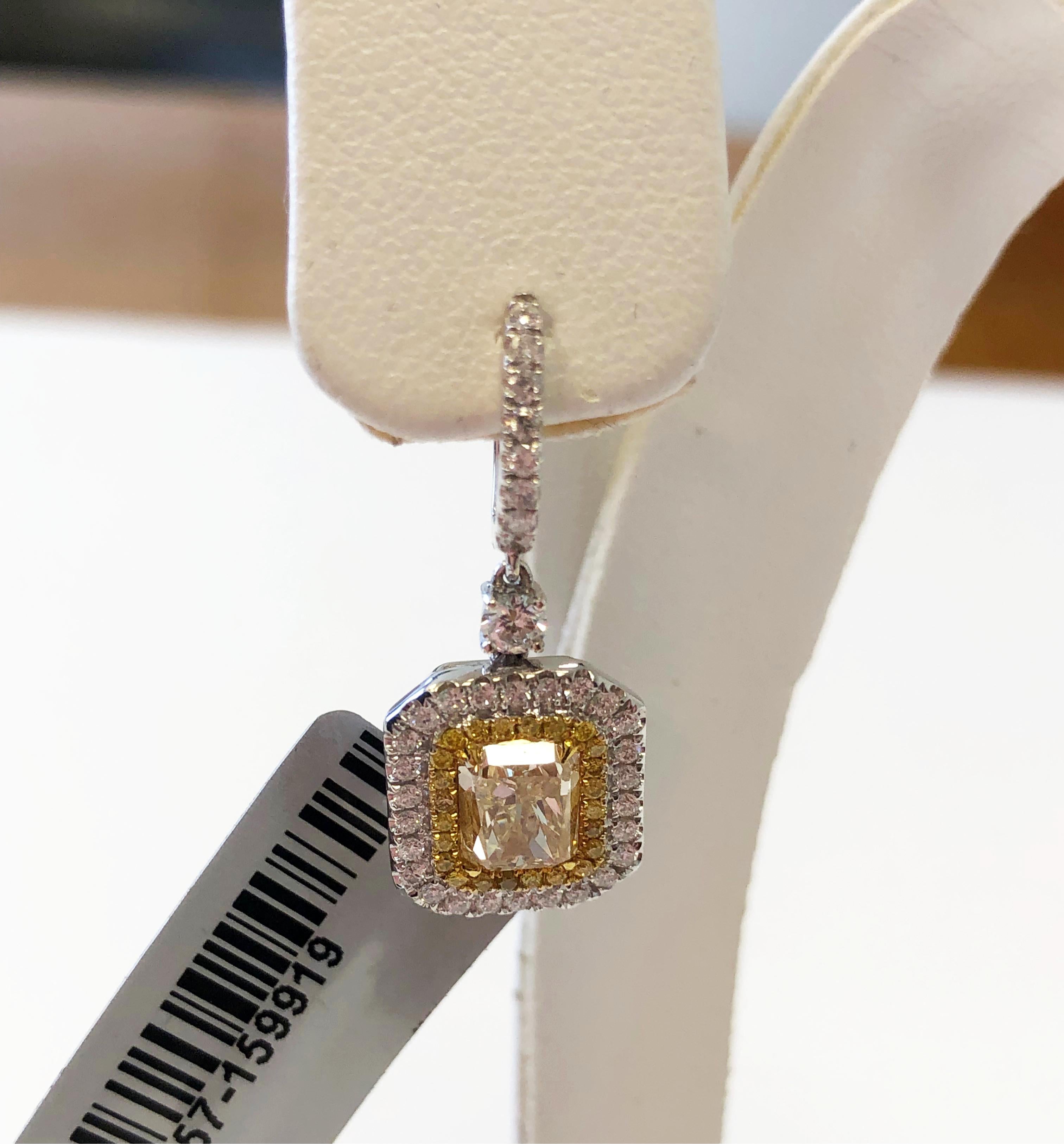 Gorgeous radiant yellow diamonds with bright white diamonds in this classic dangle earring. Yellow radiants weigh 3.06 carats with 0.97 carats of white diamonds. Handmade 18k yellow gold mounting.
