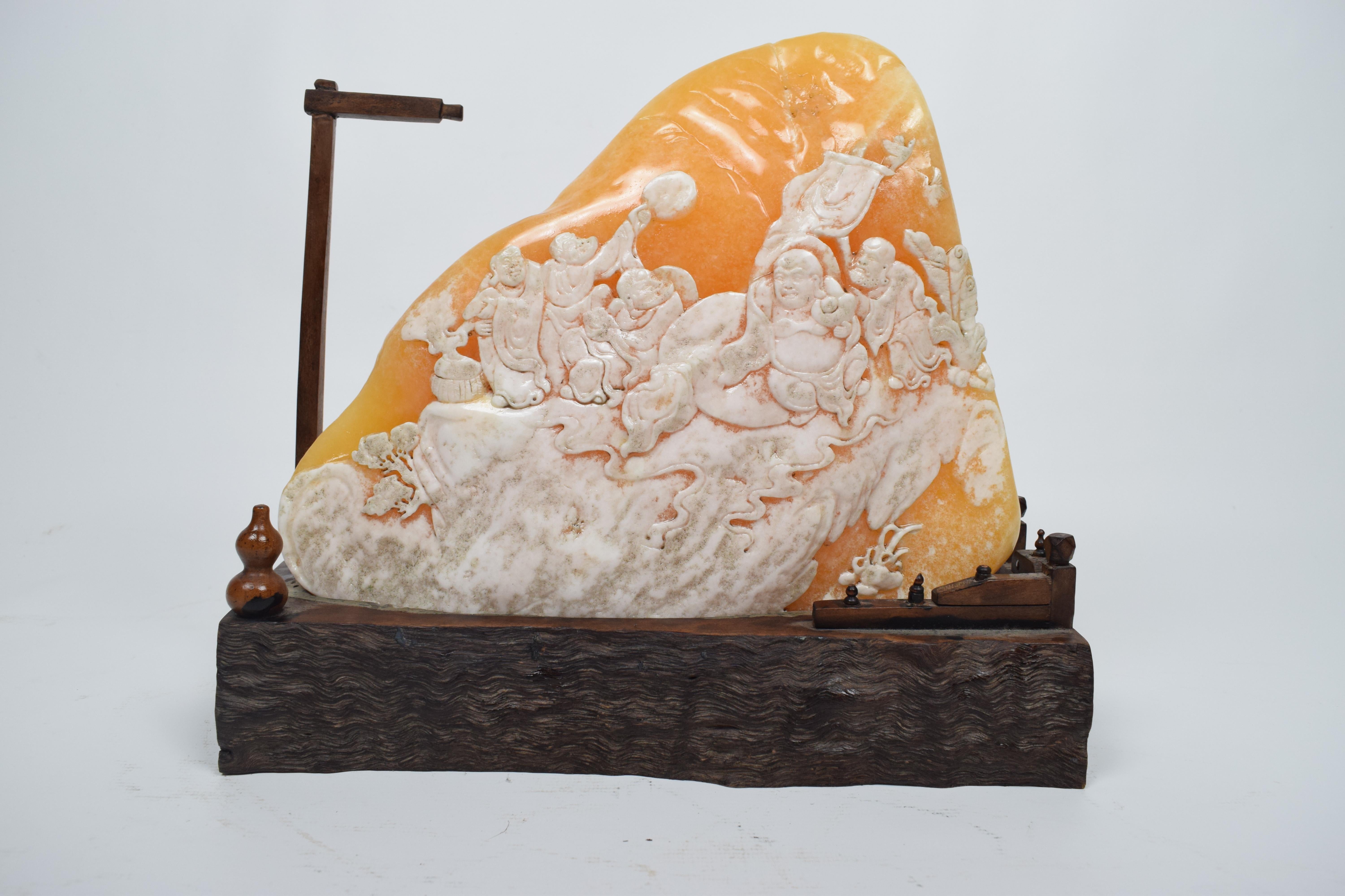 The radiating yellow soapstone carving depicts a serene and spiritually evocative scene set in the elevated hills, capturing the essence of Buddhist monks in the 20th century. The soapstone, with its warm and luminous yellow hue, adds a subtle glow
