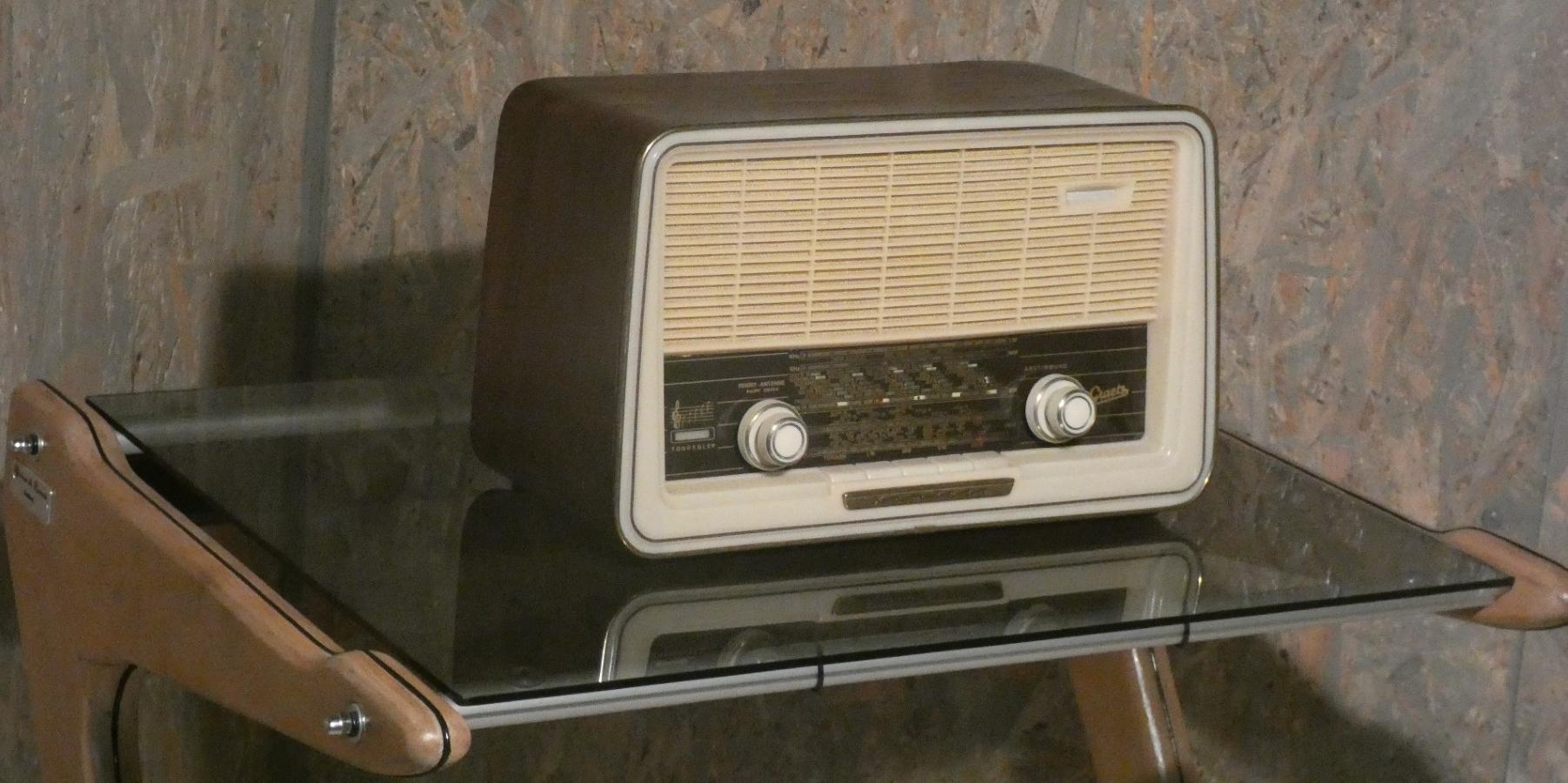 Pequeña radio de tubo de cocina fabricada en madera, latón y plástico, equipada con un ojo mágico y capaz también de transmitir en FM, con una frecuencia que oscila entre 87,5 y 100 Mhz.
El marco curvado de madera está acabado con una chapa original