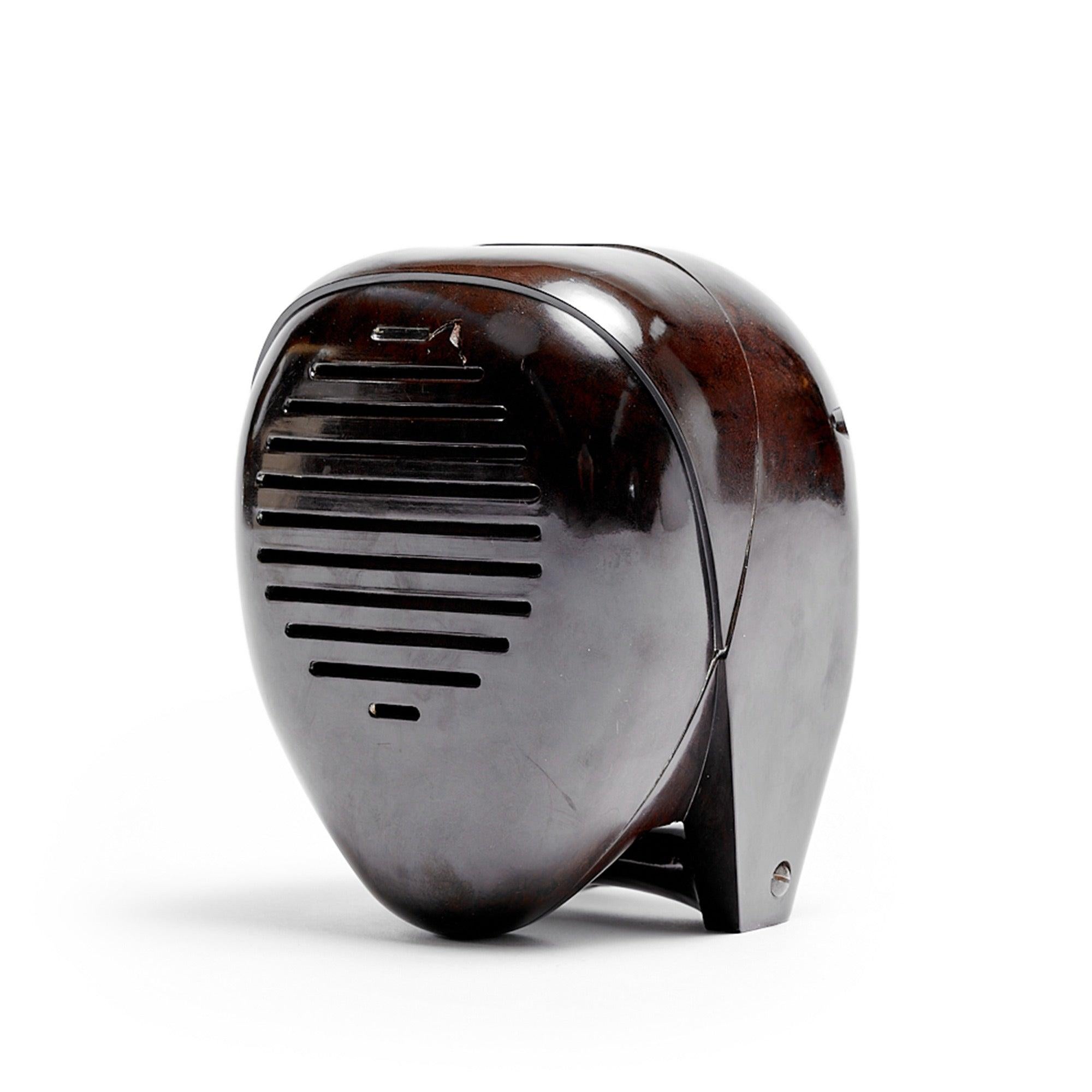 Der Künstler Isamu Noguchi entwarf ein ausdrucksstarkes Babyfon/Radioschwester aus Bakelit, dessen modernistische Form an einen abstrahierten menschlichen Kopf und traditionelle japanische Kendo-Masken erinnert.