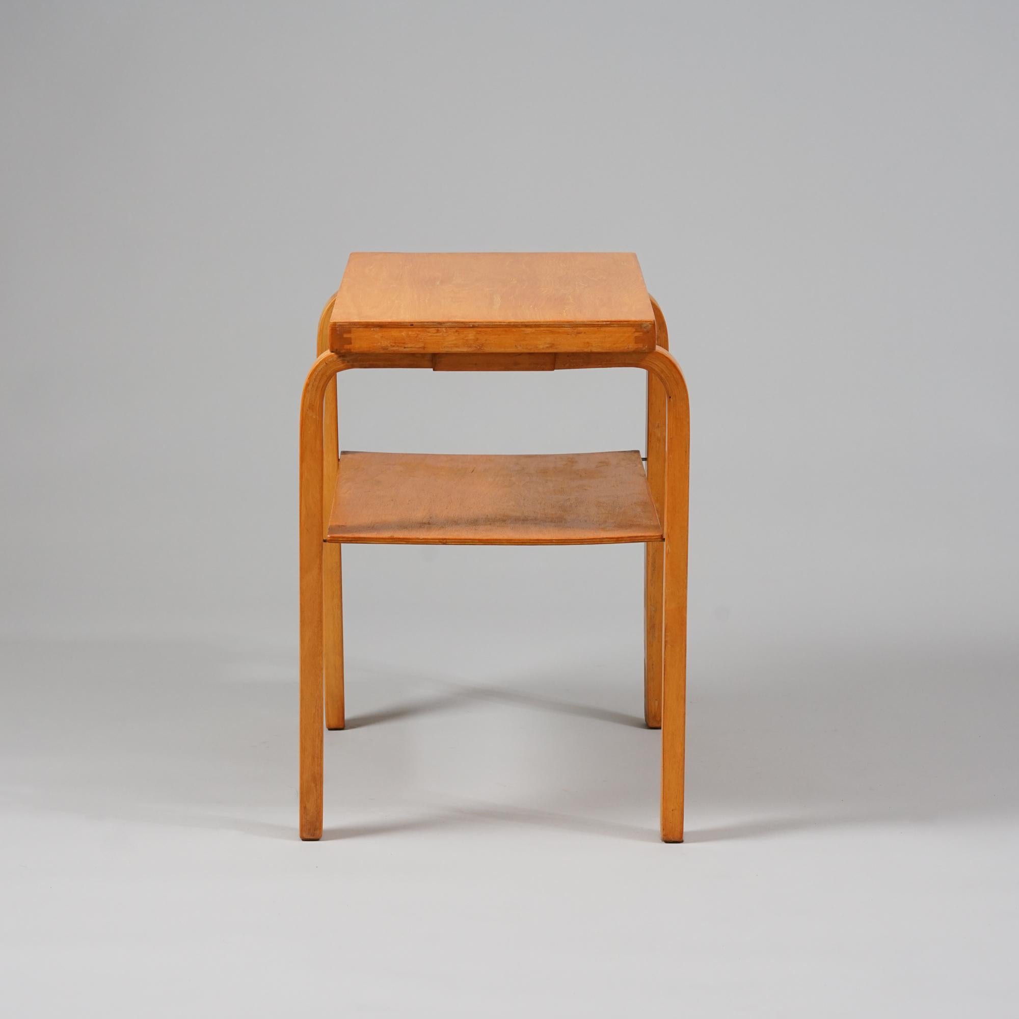 Radio table/ side table, design Alvar Aalto, manufactured by Oy Huonekalu- ja Rakennustyötehdas Ab, Mid-20th Century. Patinated honey colored birch. Good vintage condition, patina and wear consistent with age and use. 

Alvar Aalto (1898-1976) is