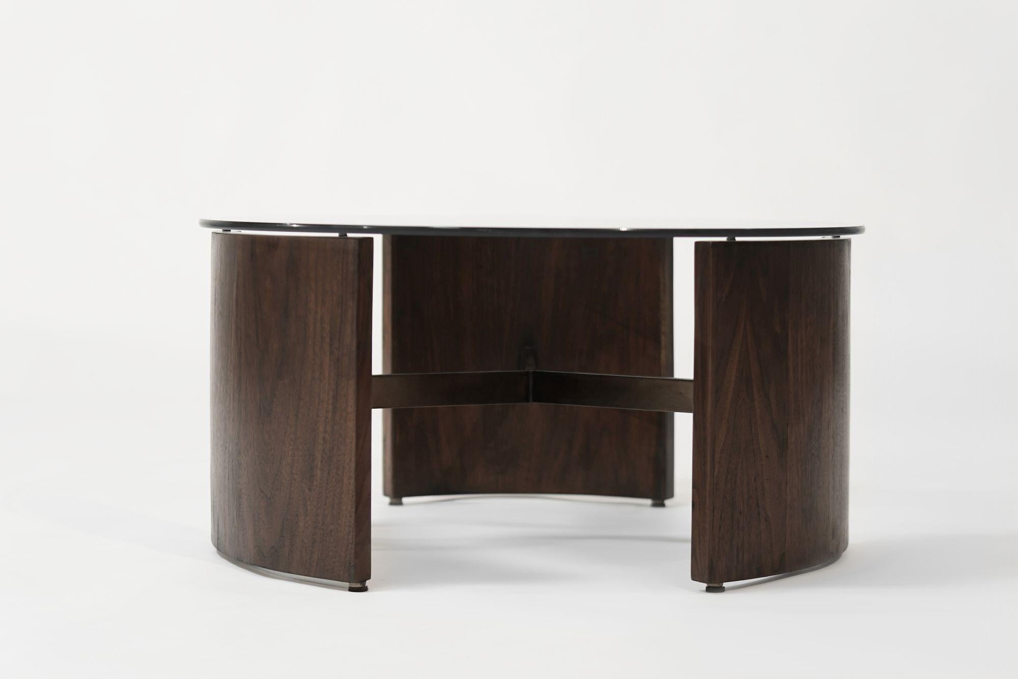 Restored vintage Vladimir Kagan Radius Table is redone in our dark walnut finish, featuring the signature nickel stretcher refinished in bronze, and a brand-new glass top. This iconic design blends sculptural elegance with timeless craftsmanship.