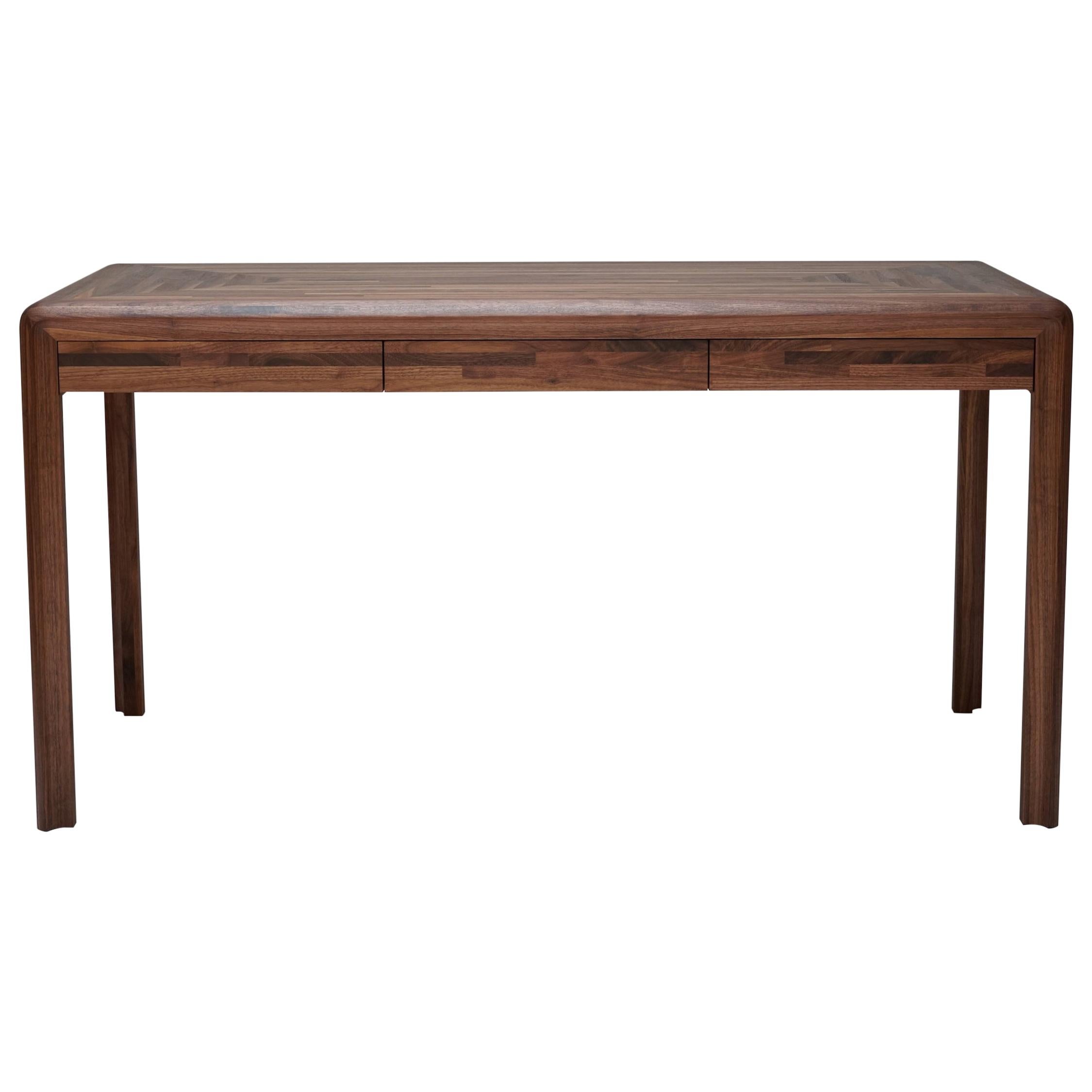 Radiused outer edges and a scalloped inner edge create a contrasting profile that adorns this minimal desk. Made from hand oiled solid walnut, this desk blends simple lines with unique subtle details. Three deep drawers with recessed pulls offer