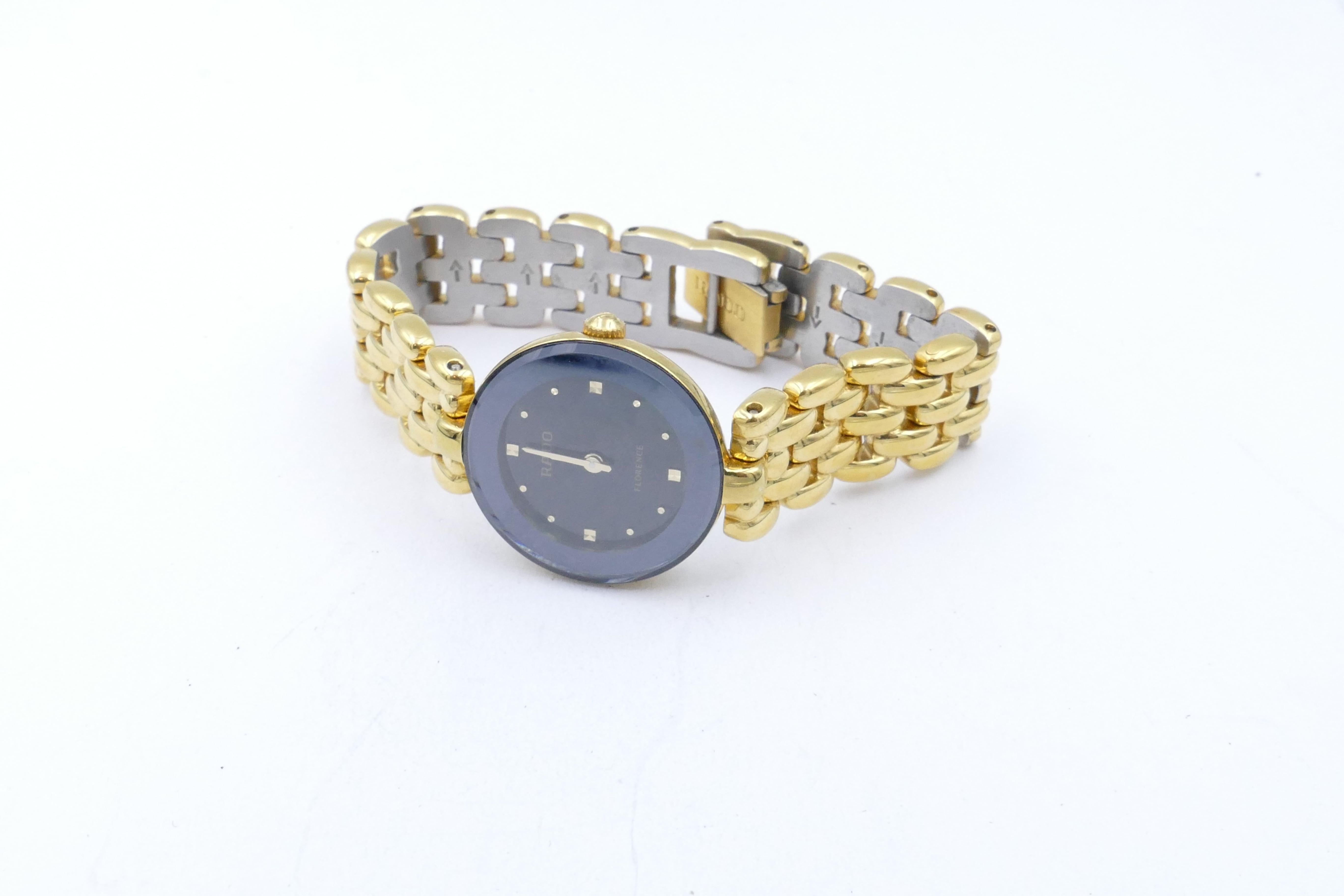 Cette montre numérotée - 153.3678.2 Rado de fabrication suisse, à cadran noir, est fabriquée en acier inoxydable recouvert d'une plaque d'or jaune avec un mouvement suisse à quartz.
Il possède des aiguilles des heures et des minutes en or ainsi que