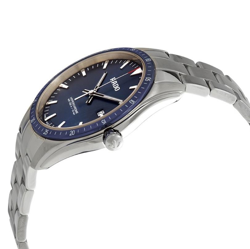 Silver-tone stainless steel case with a silver-tone stainless steel bracelet. Blue high-tech ceramic bezel. Blue dial with silver-tone hands and index hour markers. Minute markers around the outer rim. Dial Type: Analog. Luminescent hands and