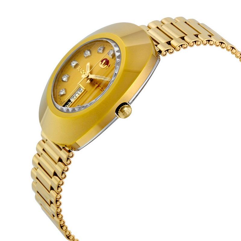Gold PVD stainless steel case and bracelet. Fixed gold PVD bezel. Gold dial with luminous gold-tone hands and diamond hour markers. Minute markers around the outer rim. Dial Type: Analog. Luminescent hands. Day of the week and date display appears