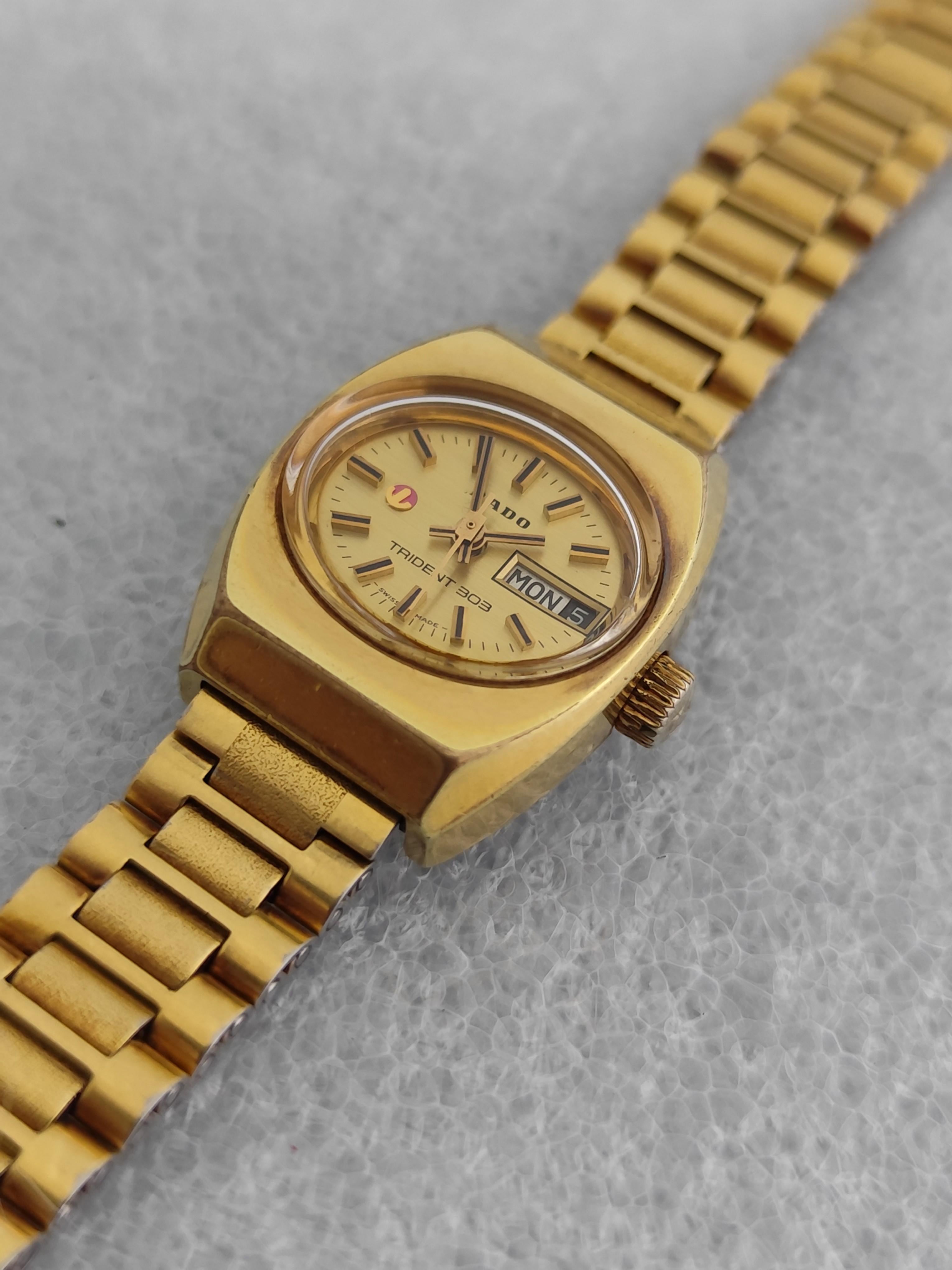  Marke : RADO

Modell: TRIDENT 303

Land der Herstellung: Schweiz

Uhrwerk: Automatik

MATERIAL des Gehäuses: Edelstahl vergoldet

Abmessungen :22 mm Durchmesser (ohne Krone)

Band Typ : Edelstahl vergoldet

Band Zustand: In Preowned Zustand mit