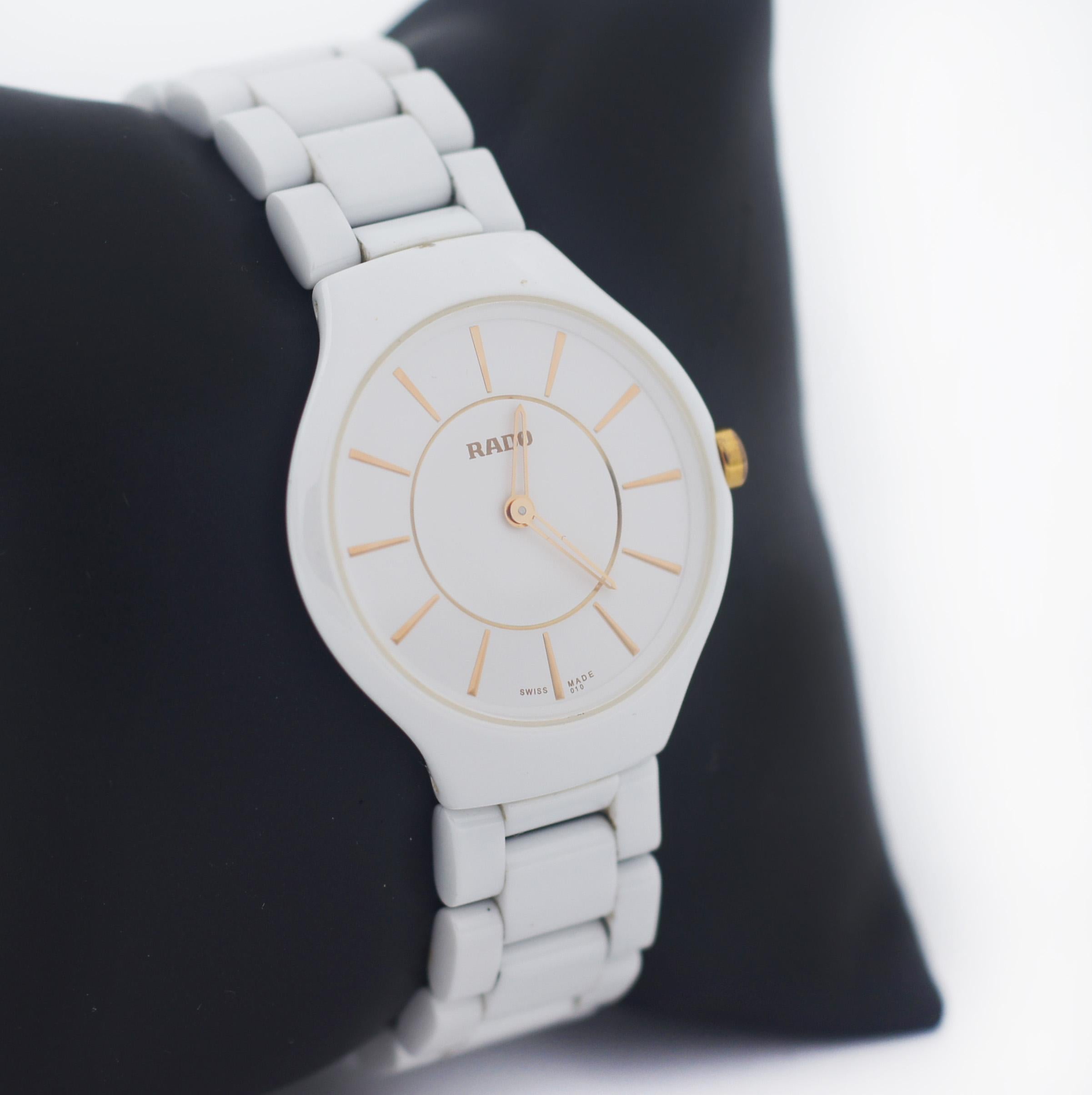 RADO
Model: True Thinline
Case White Ceramic
White Dial
Golden Markers, hands, and crown
Case Size 29 mm
Case Thickness 5mm
Fixed Bezel
Sapphire Crystal
Swiss Made
Movement Quartz
Watch Shape Round
Caseback Snap
Band White Ceramic
Band Width 15
