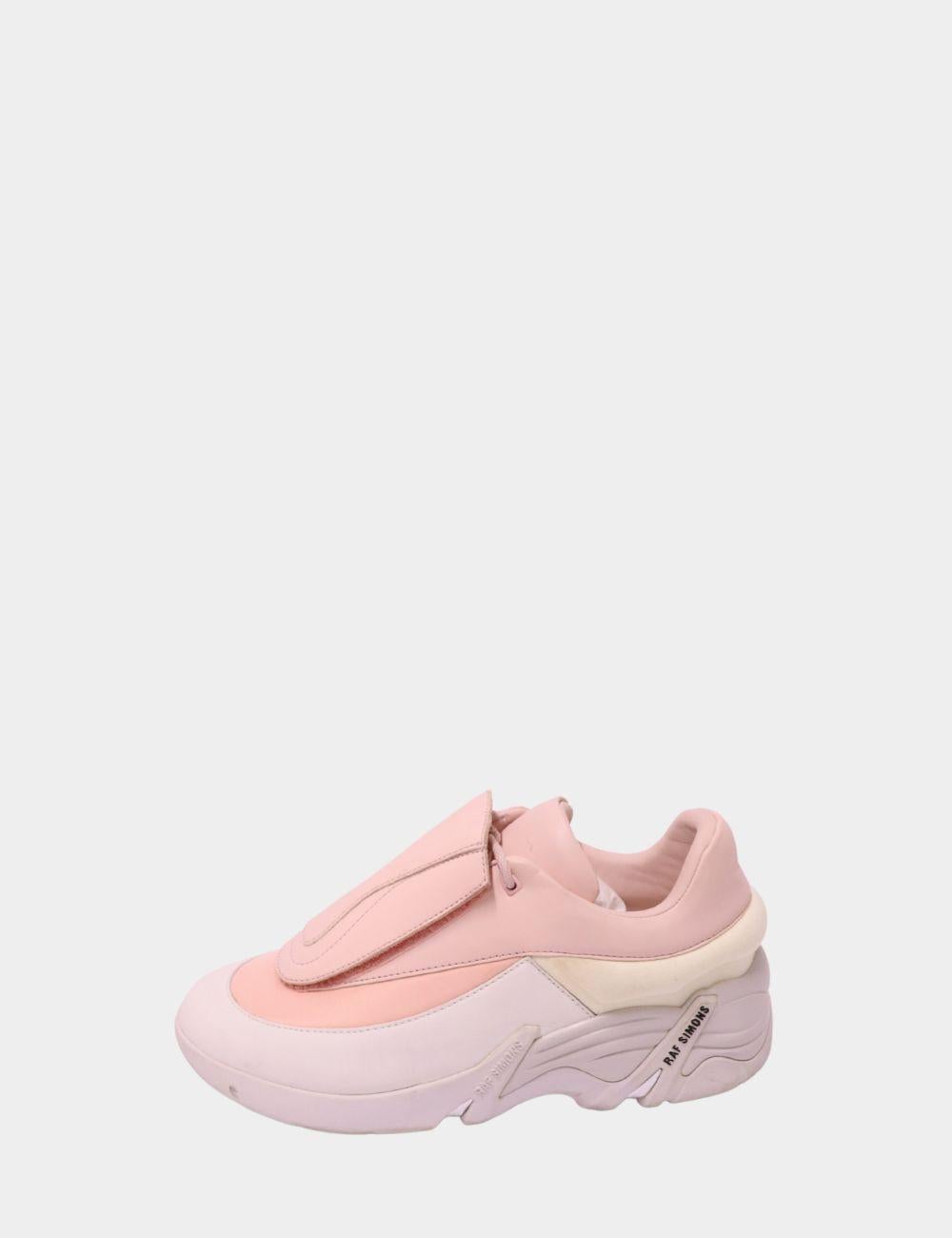 Mit diesen Plateau-Sneakern von Raf Simons in zartem Rosa und Weiß sprengen Sie die Grenzen der Streetwear. Mit futuristischen Verkleidungen, einer übertriebenen Sohle und einem eleganten schnürlosen Design sind diese Sneaker ein kühner Ausdruck der