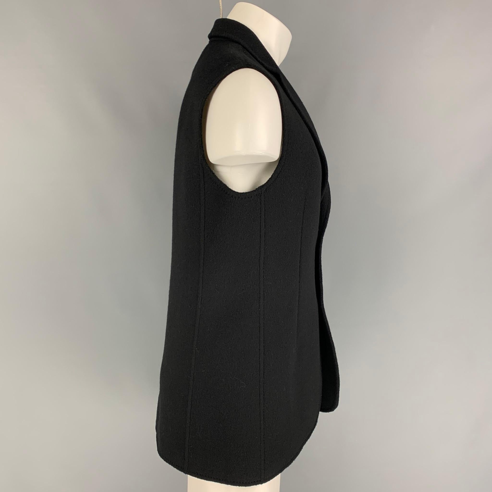 RAF SIMONS vest comes in a virgin wool featuring a notch lapel, patch pocket, and a double button closure. Made in Italy. 

Excellent Pre-Owned Condition.
Marked: 50

Measurements:

Shoulder: 17 in.
Chest: 40 in.
Length: 29.5 in. 
