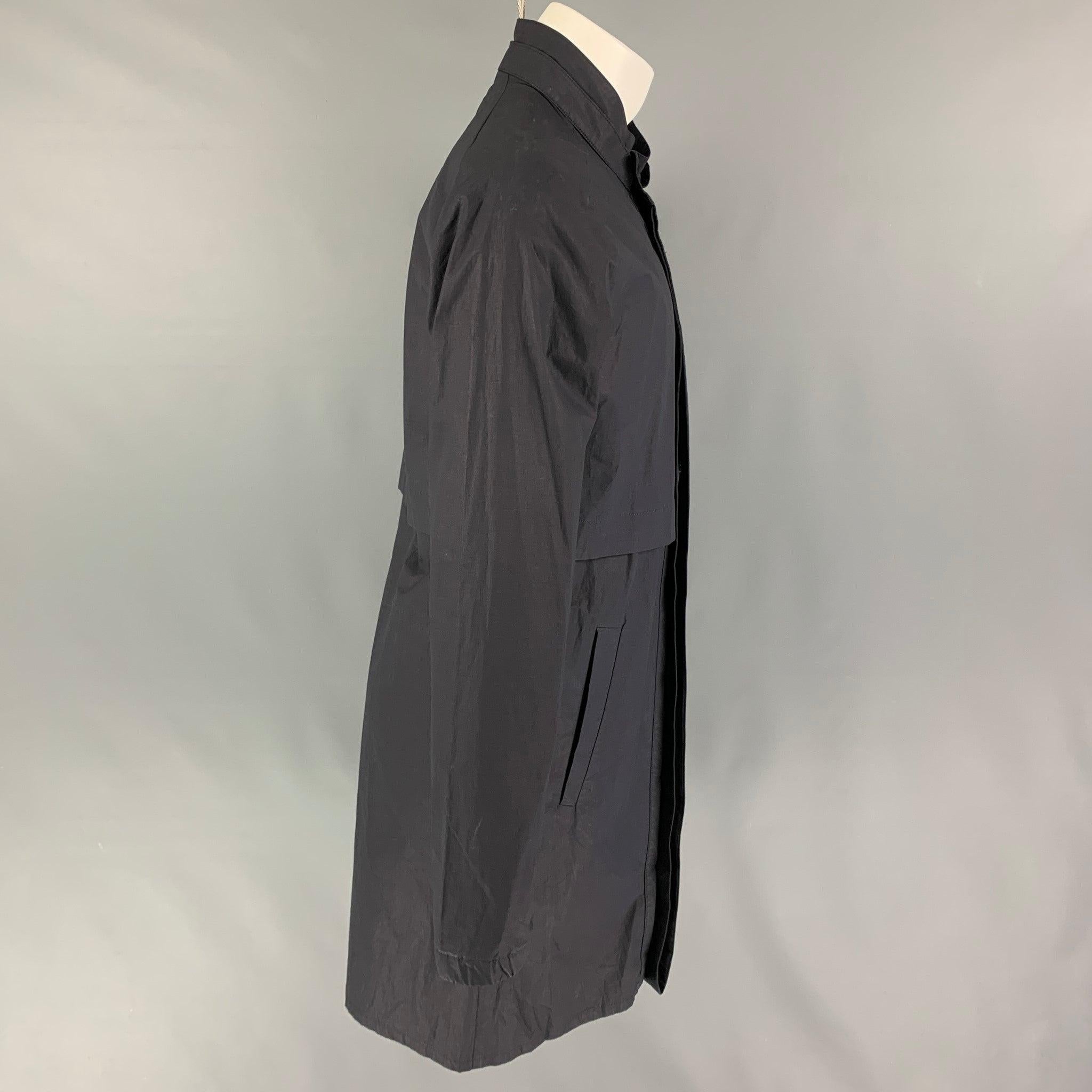 RAF SIMONS Spring-Summer 2008 coat comes in a slate cotton featuring a stand up collar, slit pockets, single back vent, and a hidden zip & buttoned closure. Made in Romania.
Very Good
Pre-Owned Condition. 

Marked:  50 

Measurements: 
 
Shoulder: