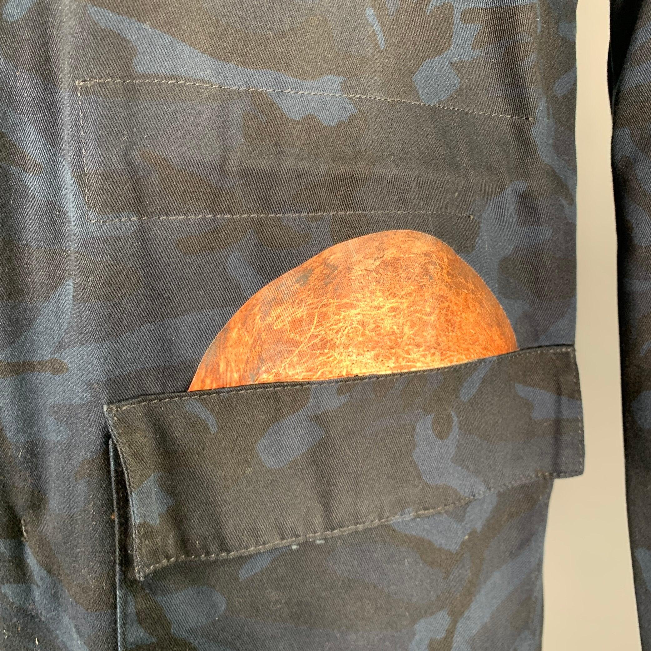 RAF SIMONS x STERLING RUBY coat
in a navy and black cotton woven fabric featuring a camouflage pattern, space and nature themed prints, and zip & snaps closure. Made in Italy.Very Good Pre-Owned Condition. Minor marks and signs of wear on prints.