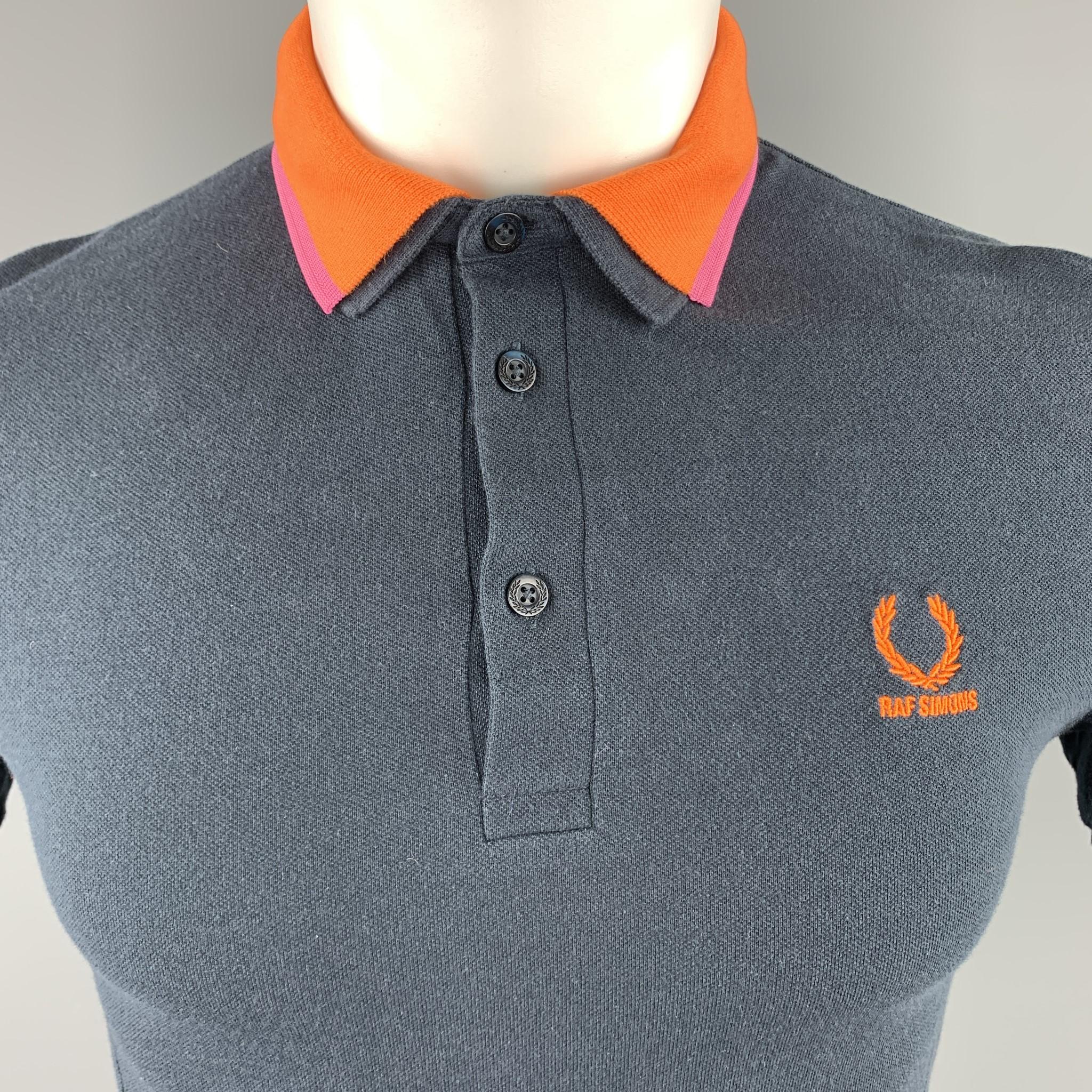 FRED PERRY x RAF SIMONS polo comes in navy cotton pique with an orange embroidered logo and detachable orange and pink striped collar. Made in Portugal.

Good Pre-Owned Condition.
Marked: US 36

Measurements:

Shoulder: 16.5 in.
Chest: 36
