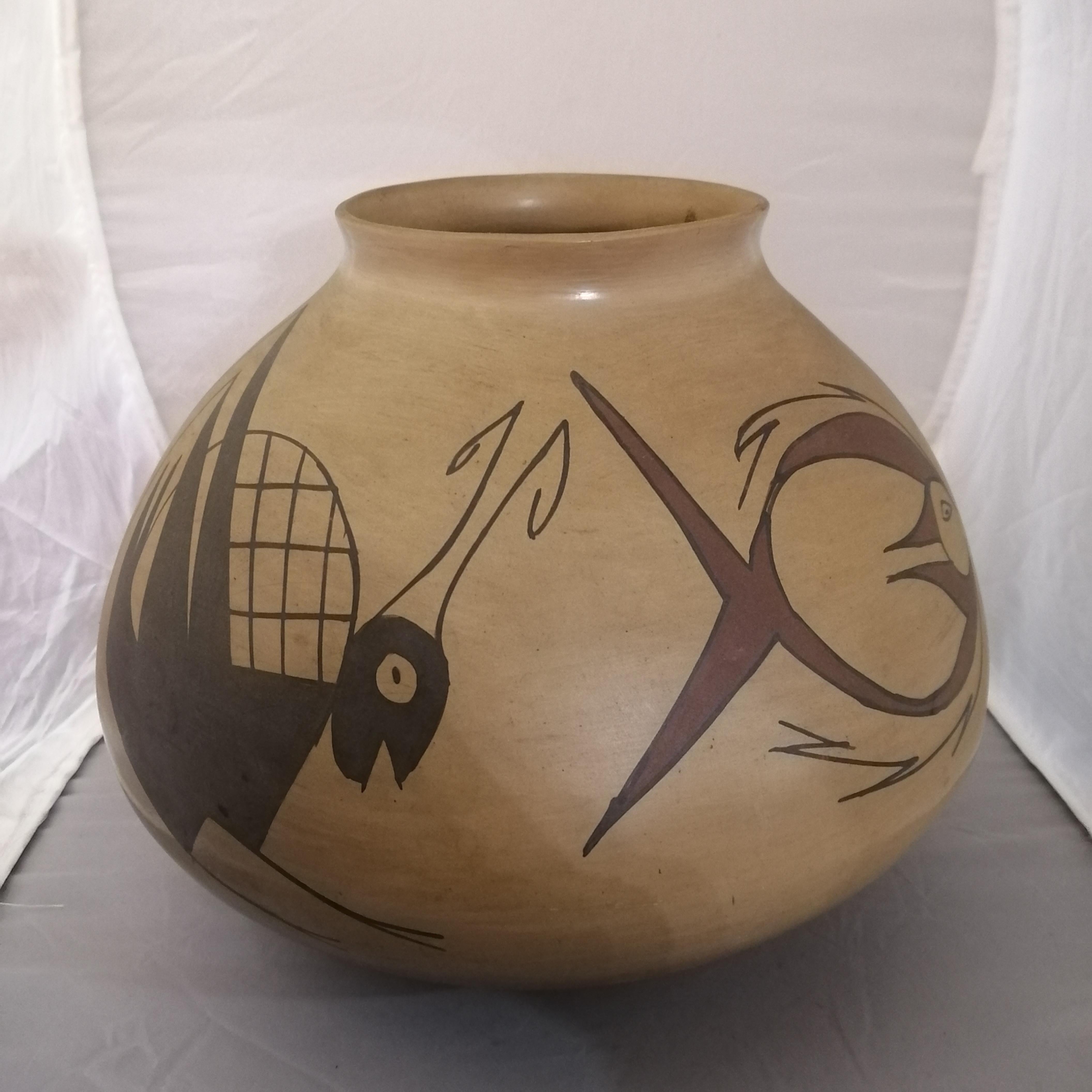 A fine Mata Ortiz pottery flower vase by Rafael Silveira. The bulged pottery shows four animal figures: a fish, a lizard, a grasshopper and another zoomorphic being. The vase is signed below.