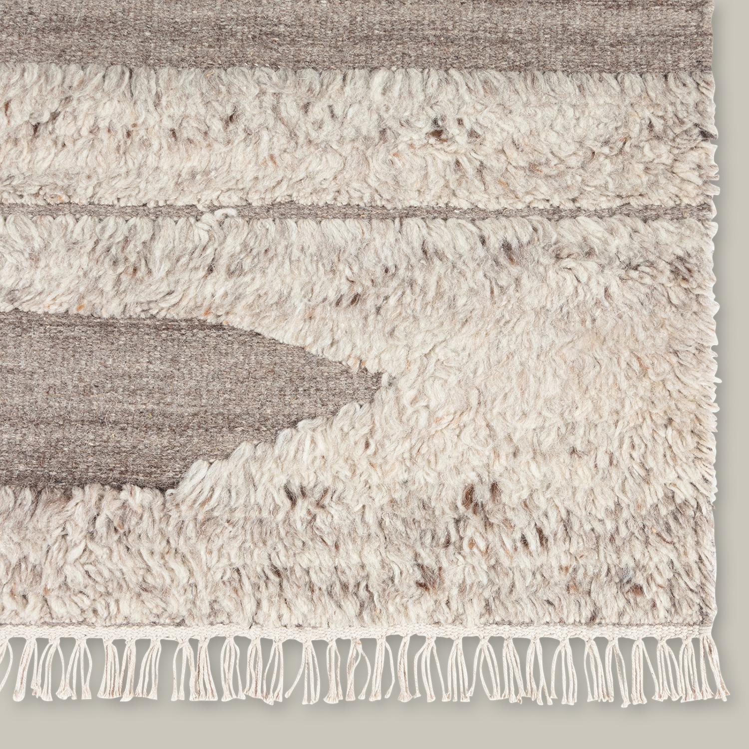 Inspired by the beauty of sun-aged natural elements, the Rafalla Collection honors the abstract beauty of a stark landscape. Handmade with natural, undyed wool and inspired by wonderfully shaggy Tulu rugs, this line features a high-low pile that