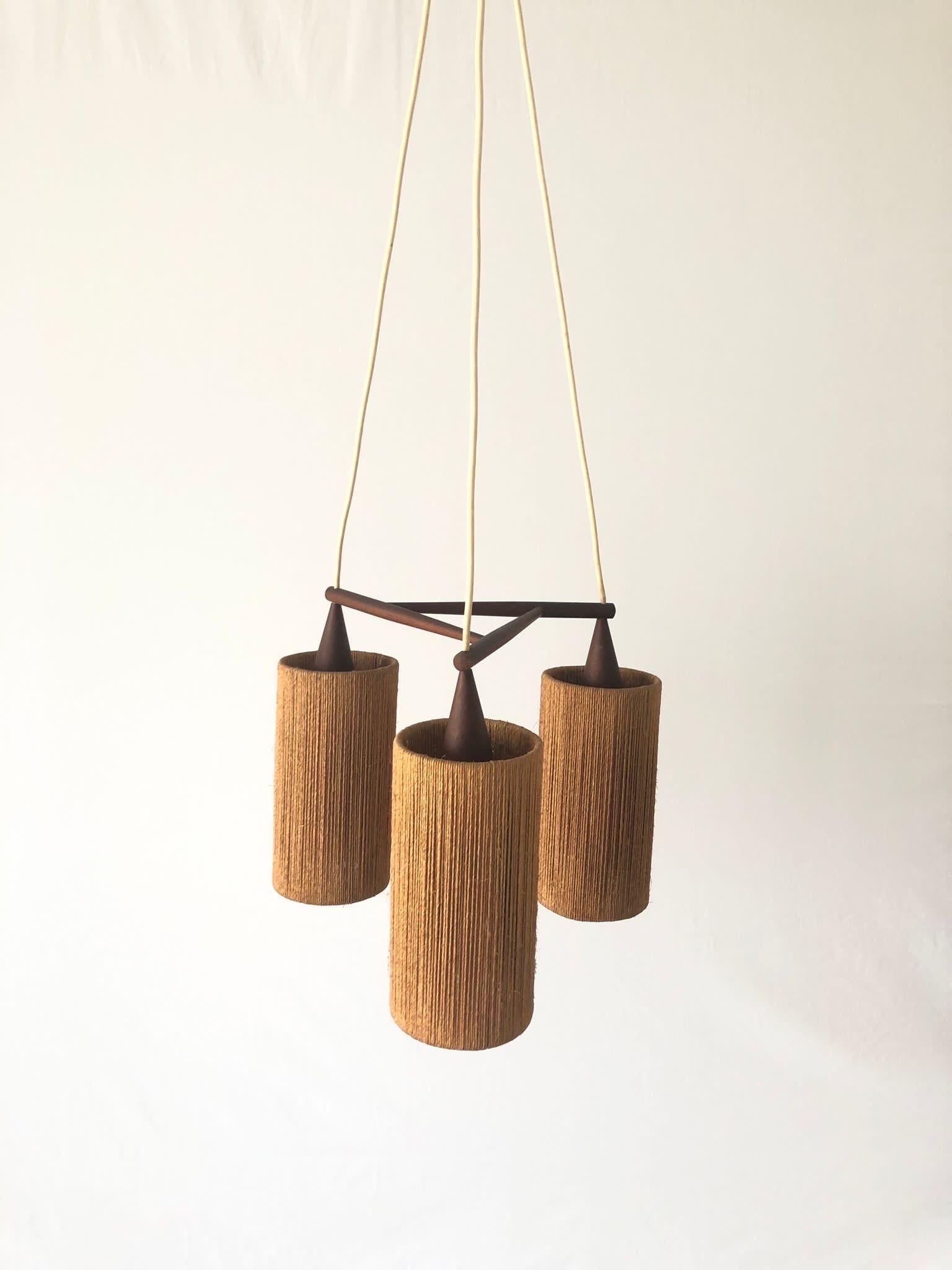 Raffia Bast and Teak Triple Pendant Lamp by Temde, 1960s, Germany

Elegant and minimal design hanging lamp

Lampshade is in good condition and very clean. 
This lamp works with 3x E14 light bulb. 
Wired and suitable to use with 220V and 110V for all