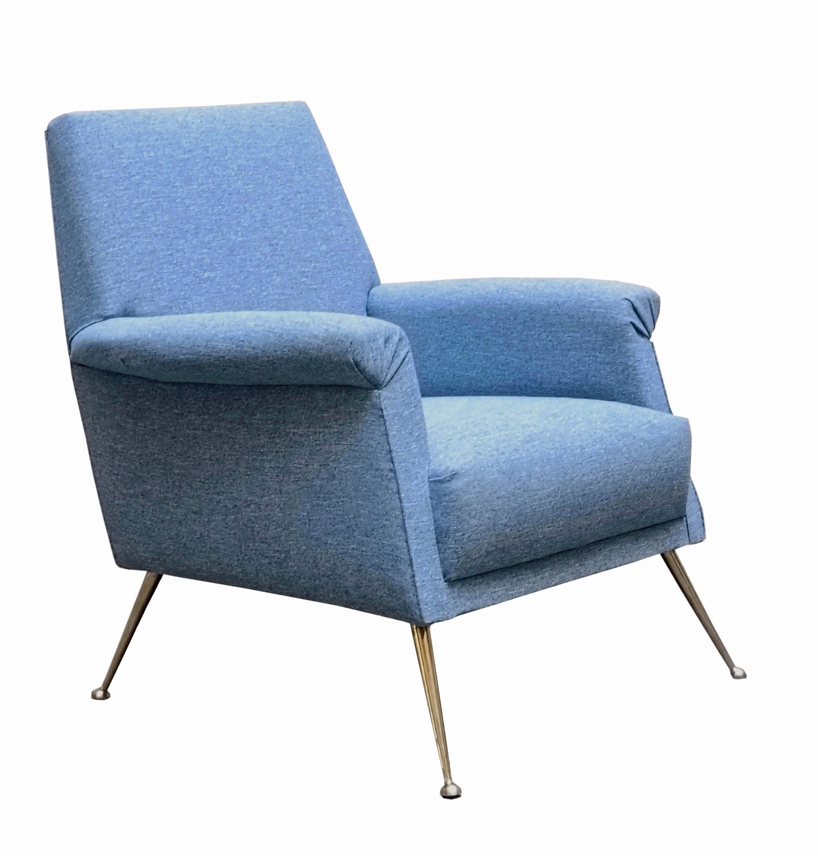 Magnifique fauteuil italien des années 1960 avec un large dossier et des accoudoirs rembourrés offrant un grand confort et un bon soutien. La tapisserie est en tissu bleu poudre et les pieds sont en laiton.