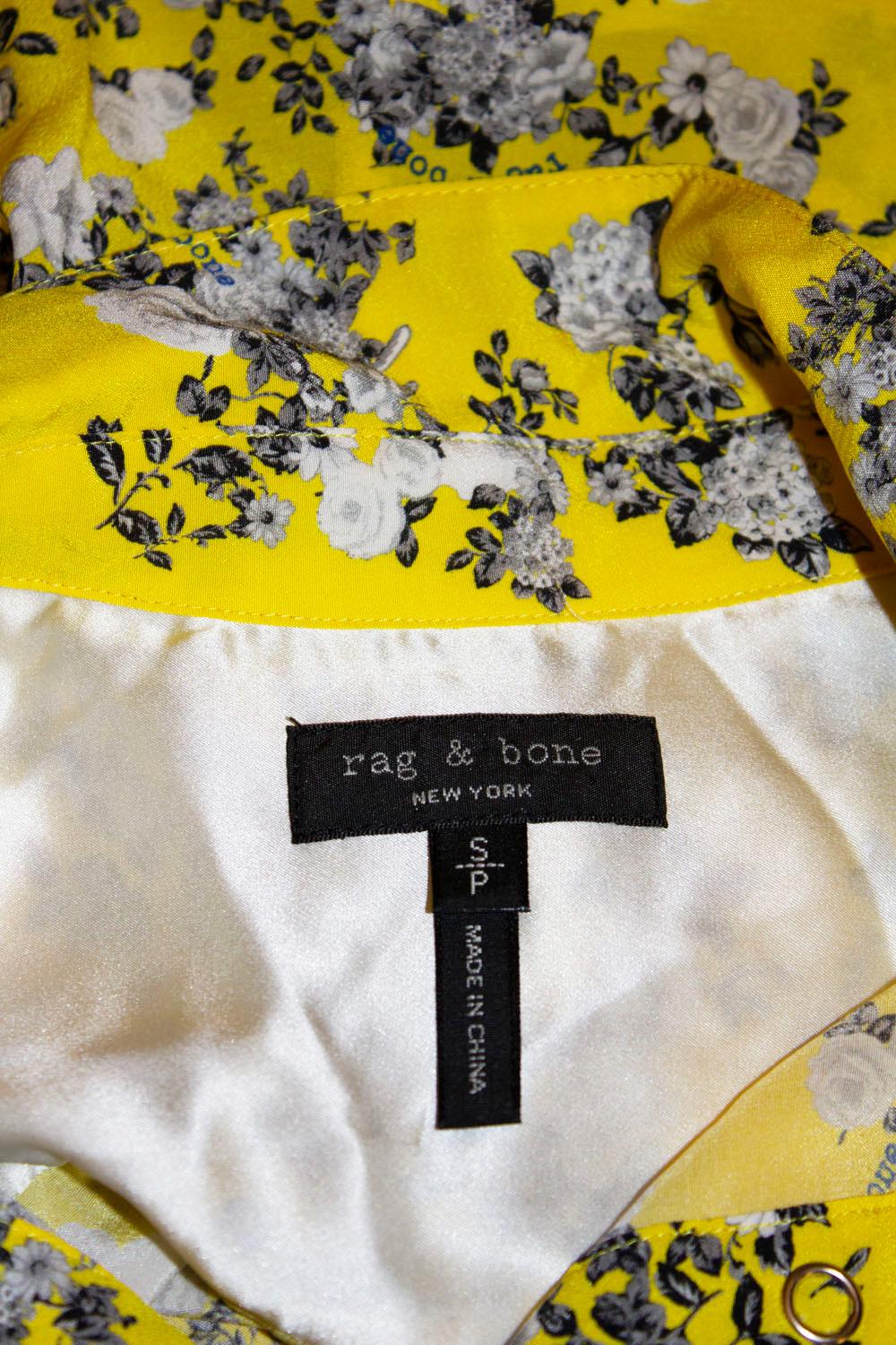 A pretty silk shirt, perfect for Spring /Summer from Rag and Bone.  The shirt is in a lovely silk, with a yellow background and floral print, and button opening.
Measurements: Bust up to 34''.length  front 29'',  back 34''