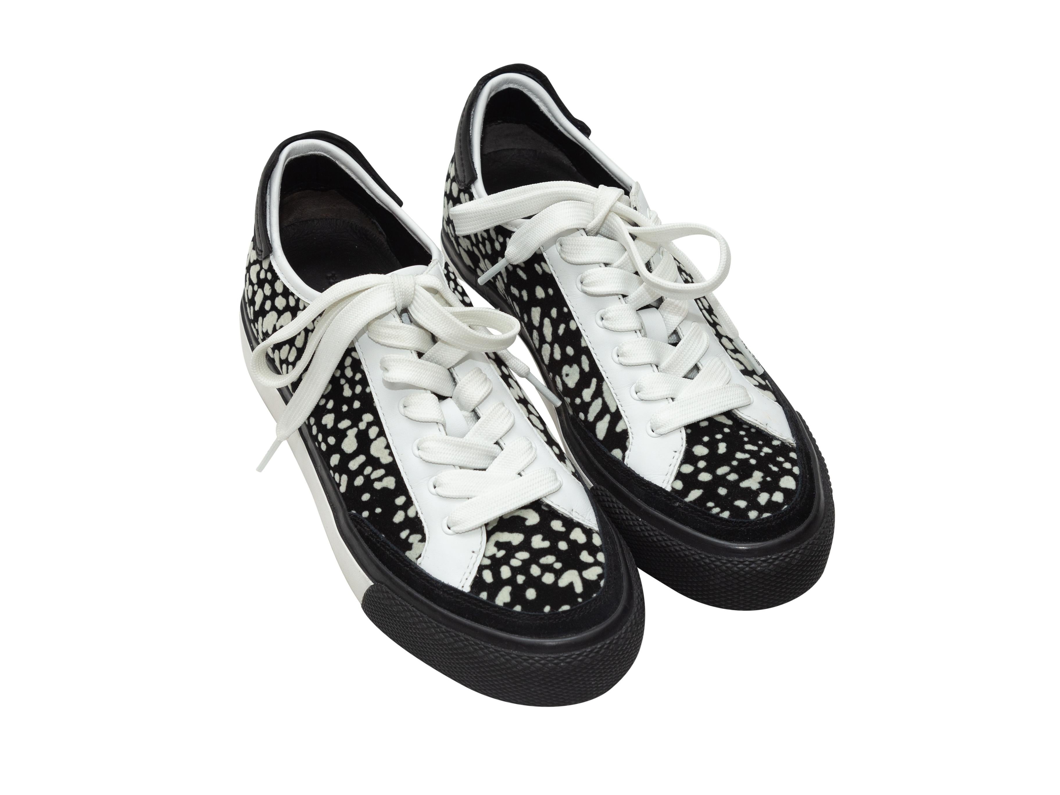 Product details: Black and white low-top sneakers by Rag & Bone. Dotted print throughout. Rubber soles. Lace-up tie closures at top. 1