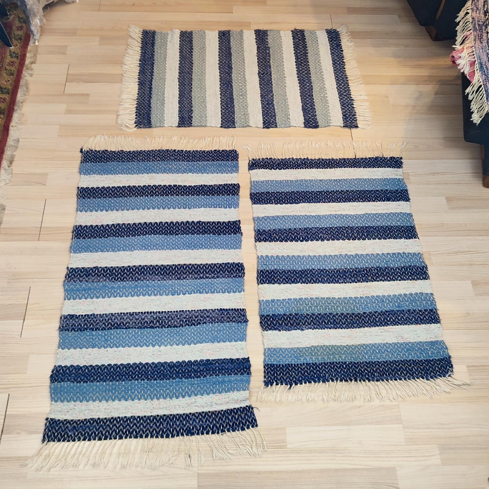 Mid-20th-century Swedish set of 3 rag rugs. 
Design in alternate stripes of blue shades and ecru.
Dimensions:
65x130 cm
65x115 cm
65x115 cm

In a very good used condition. 