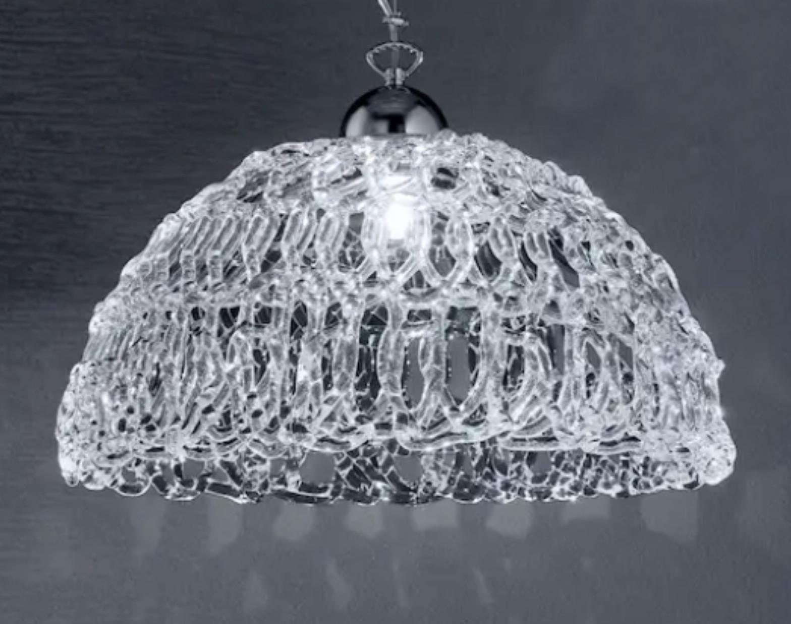 Lampadario a sospensione italiano con paralume in vetro di Murano trasparente soffiato a mano per formare una trama organica a ragnatela, montato su ferramenta cromata / Made in Italy
1 luce / tipo E26 o E27 / max 60W
Misure: Diametro 18 pollici /