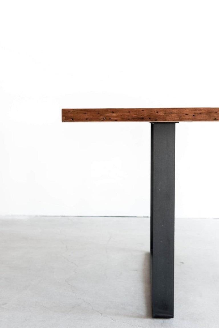 Cette table à manger en forme de wagon est fabriquée sur mesure à Los Angeles. Les planches de bois récupéré sont coupées à la bonne taille et assemblées. Le métal est plié à la forme et soudé. 

Le bois de récupération présente une large gamme de