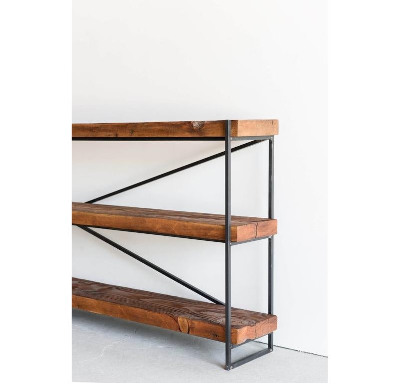 This Bookcase is Custom Made in Los Angeles. The industrial metal frame is welded and salvaged wood beams are cut to size and attached to the frame.

Reclaimed wood has a wide range of color and texture due to weathering. The wood is up cycled from
