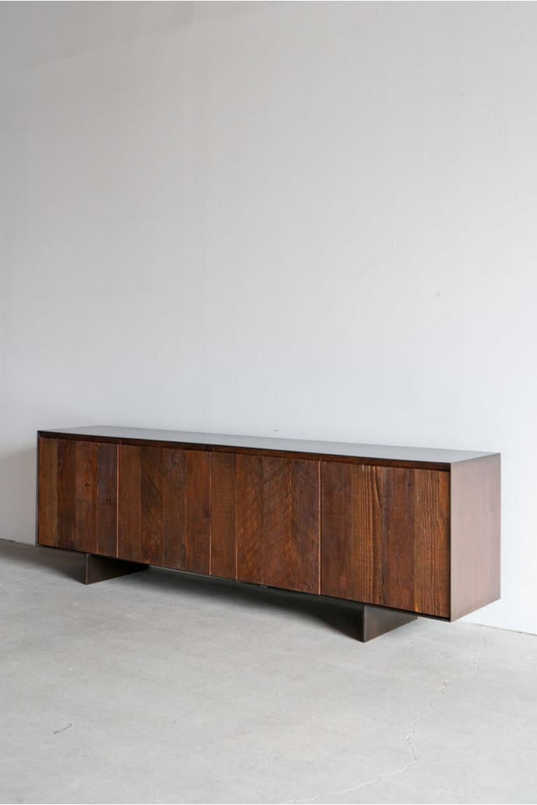 Questa credenza è realizzata su misura a Los Angeles. L'involucro di acciaio industriale viene tagliato a misura e attaccato a un substrato, per poi essere patinato in modo antico. Il Wood viene tagliato a misura e unito alla faccia della porta.