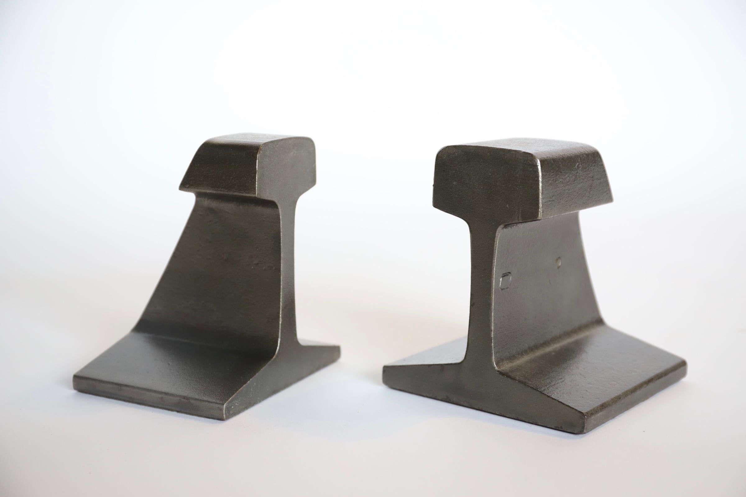 Fun whimsical solid iron railroad tie bookends. Raw metal with clear coat and original felt bottoms. A wonderful addition to any designer interior space. Pictured with magazine sized Los Angeles Modern Auction catalogs for scale.