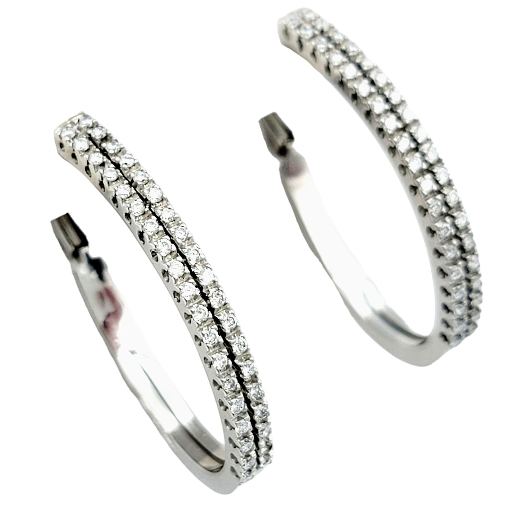 These stunning Raima diamond hoop earrings exude timeless elegance and sophistication. Crafted with meticulous attention to detail, each earring features two columns of round diamonds adorning the front side of the hoops, creating a captivating