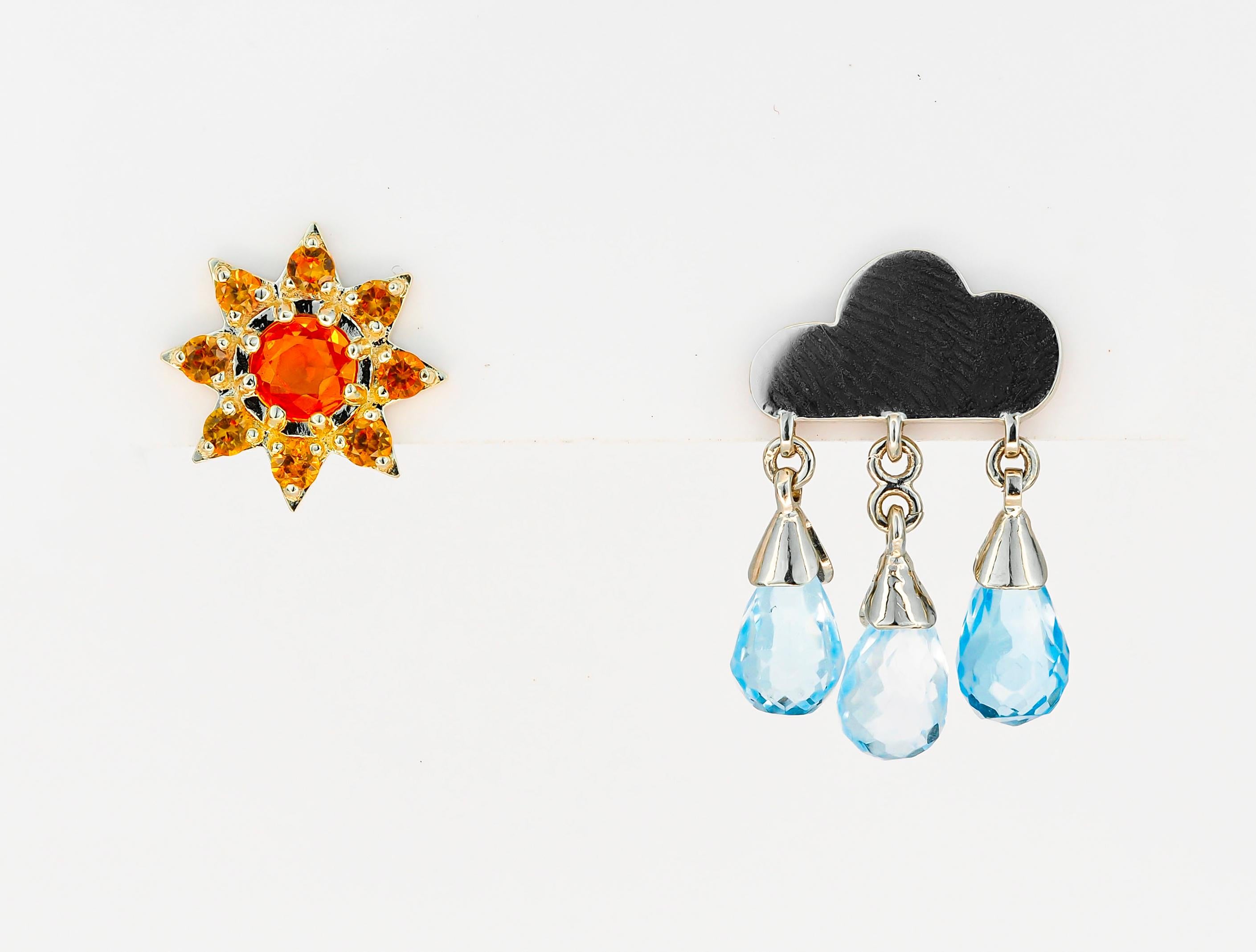Rain and sun 14k gold earring studs. 
Mismatched earrings. Weather inspired earrings. Natural topaz, sapphire studs. Teardrop earrings.

14k yellow and white gold
Weight: 3.15 g. 

1. Rain cloud
white 14k gold
Size: 19x12mm
Gemstones:
3 topazs, blue