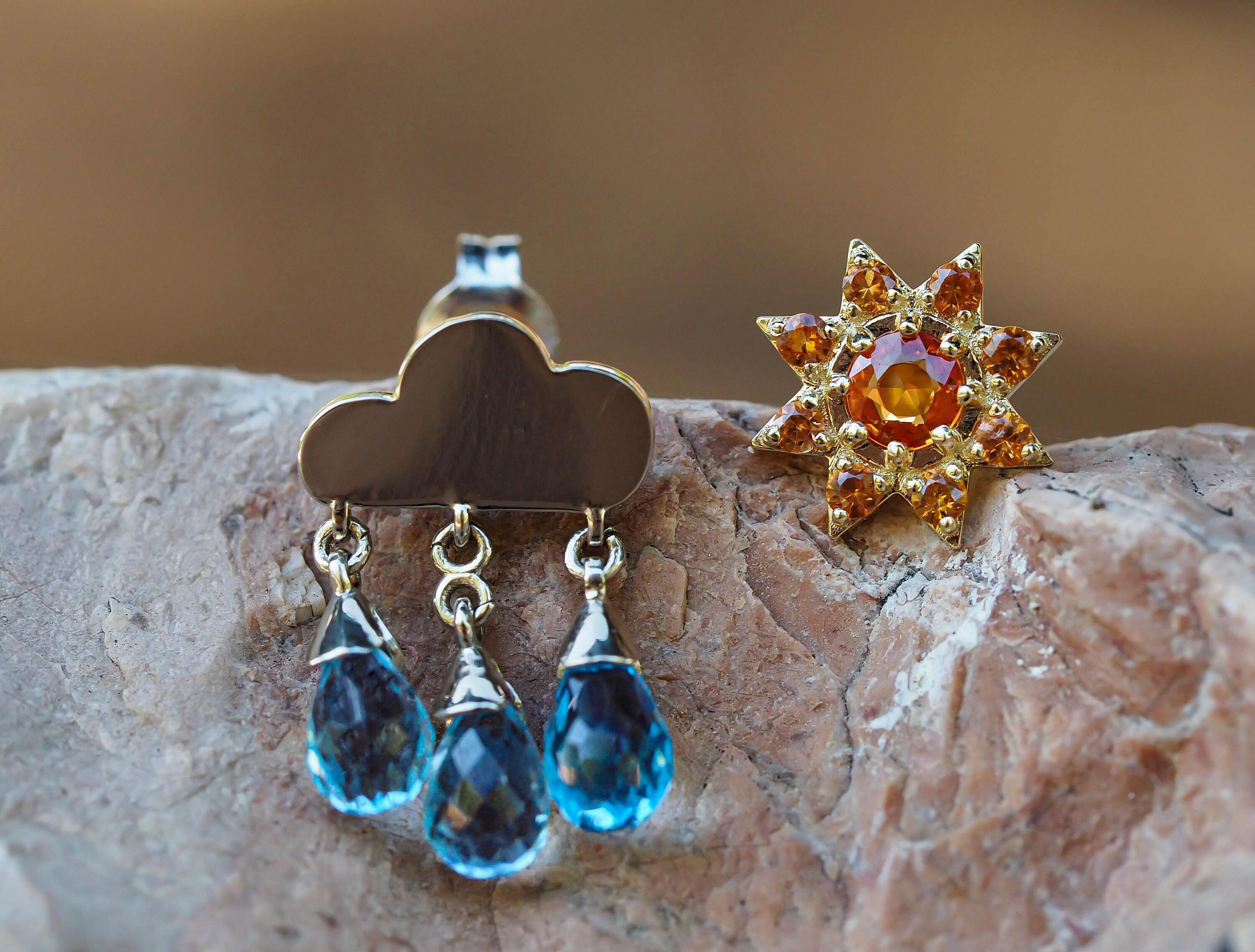 Ohrringe aus massivem 14-karätigem Gold in 925er Silber. Ungleiche Gold-Ohrstecker: Regenwolke und Sonne. Vom Wetter inspirierte Ohrringe.

Metall: 925 Silber
Gewicht: 3,15 g.

1. Regenwolke
Größe: 19 x 12 mm.

Edelsteine:
3 natürliche Topase, blaue