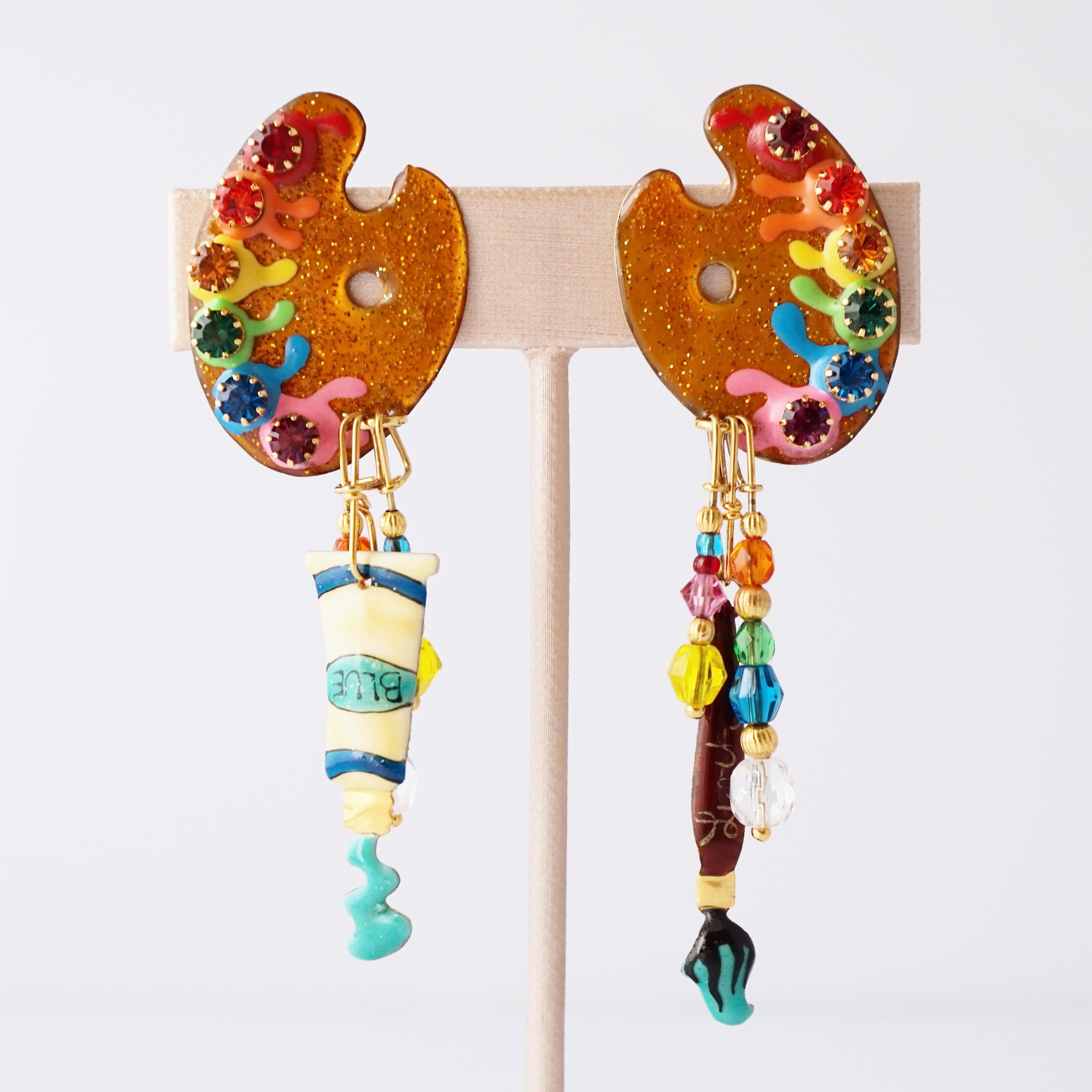 These 1980s statement stunners are pure wearable whimsy, straight from the golden age of maximalism. Each earring is a miniature art studio in motion — glittery enamel palettes dotted with rainbow “paints,” jeweled accents that sparkle like