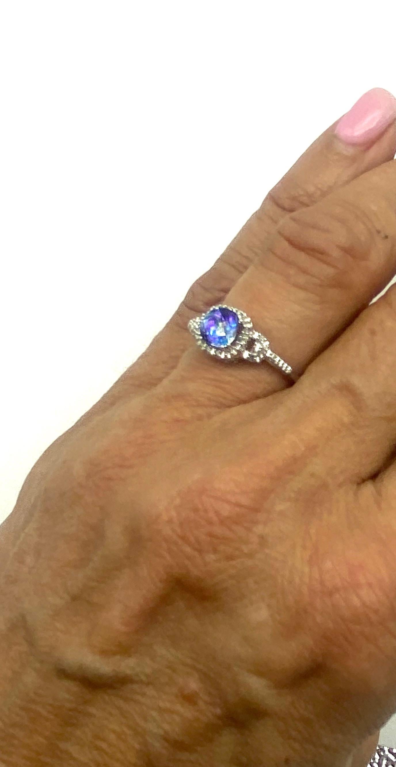 Mystic Topaz Diamond Halo Ring White Gold

This sweet ring is stunning as the color sparkles with the radiance of blue in a tapestry cut stone.
 The stone is called a cushion .The ring measures 8.18 mm wide at the halo.
Finger size is 7
15- diamonds